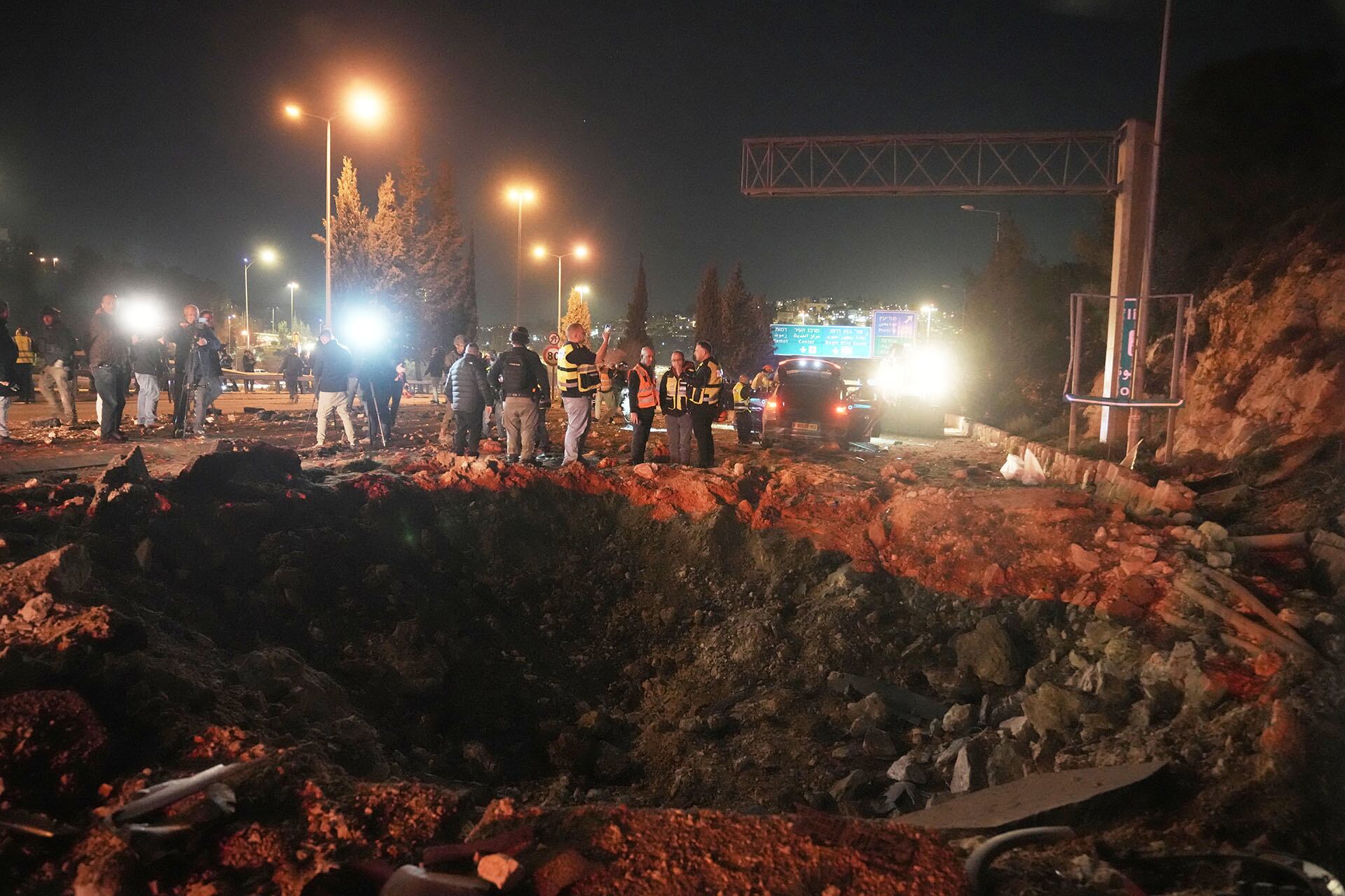 Fuerzas de seguridad israelíes inspeccionan los daños causados en una carretera por un misil lanzado desde Irán, en Jerusalén.(AP Foto/Mahmoud Illean)