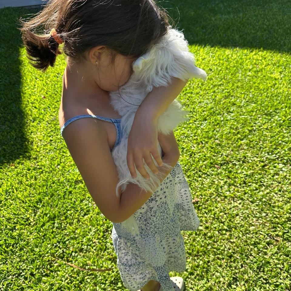 Belita, hija mayor de Isabel, abrazando a la cachorra luego de una tarde en el jardín