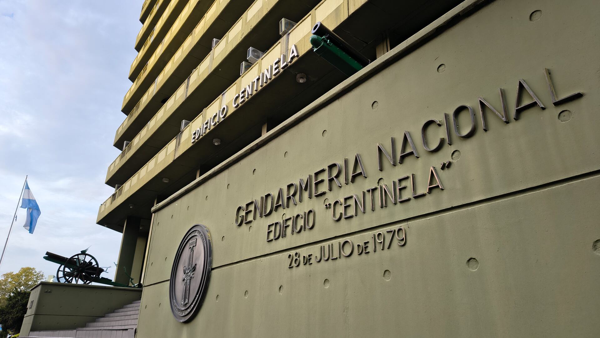 Vista del Edificio Centinela de la Gendarmería Nacional Argentina, mostrando su arquitectura brutalista, la bandera nacional y un cañón histórico en su exterior. (Adrián Escandar)