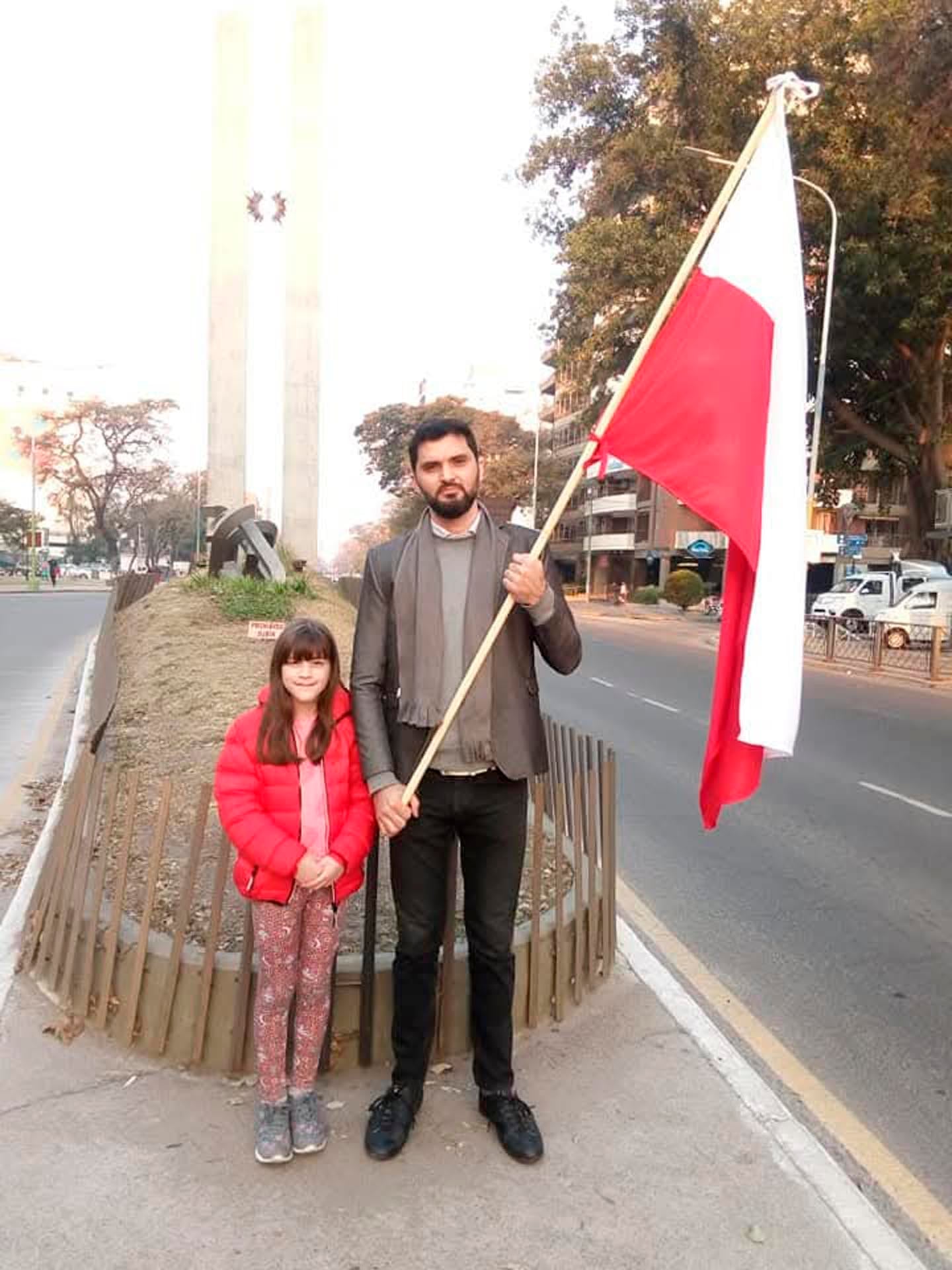 Francisco Condorí y su hija posan con la bandera polaca frente al Monumento al Bicentenario, en el parque Avellaneda de Tucumán. Esa imagen se hizo viral y le permitió cumplir la promesa que había hecho su bisabuelo