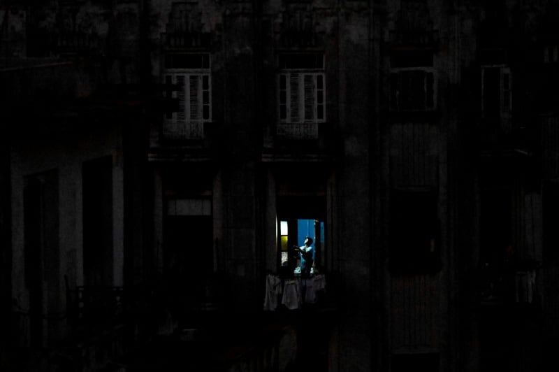 Un hombre usa una linterna tras el colapso de la red eléctrica nacional en La Habana, Cuba. 21 de marzo de 2026. REUTERS/Norlys Pérez/Archivo