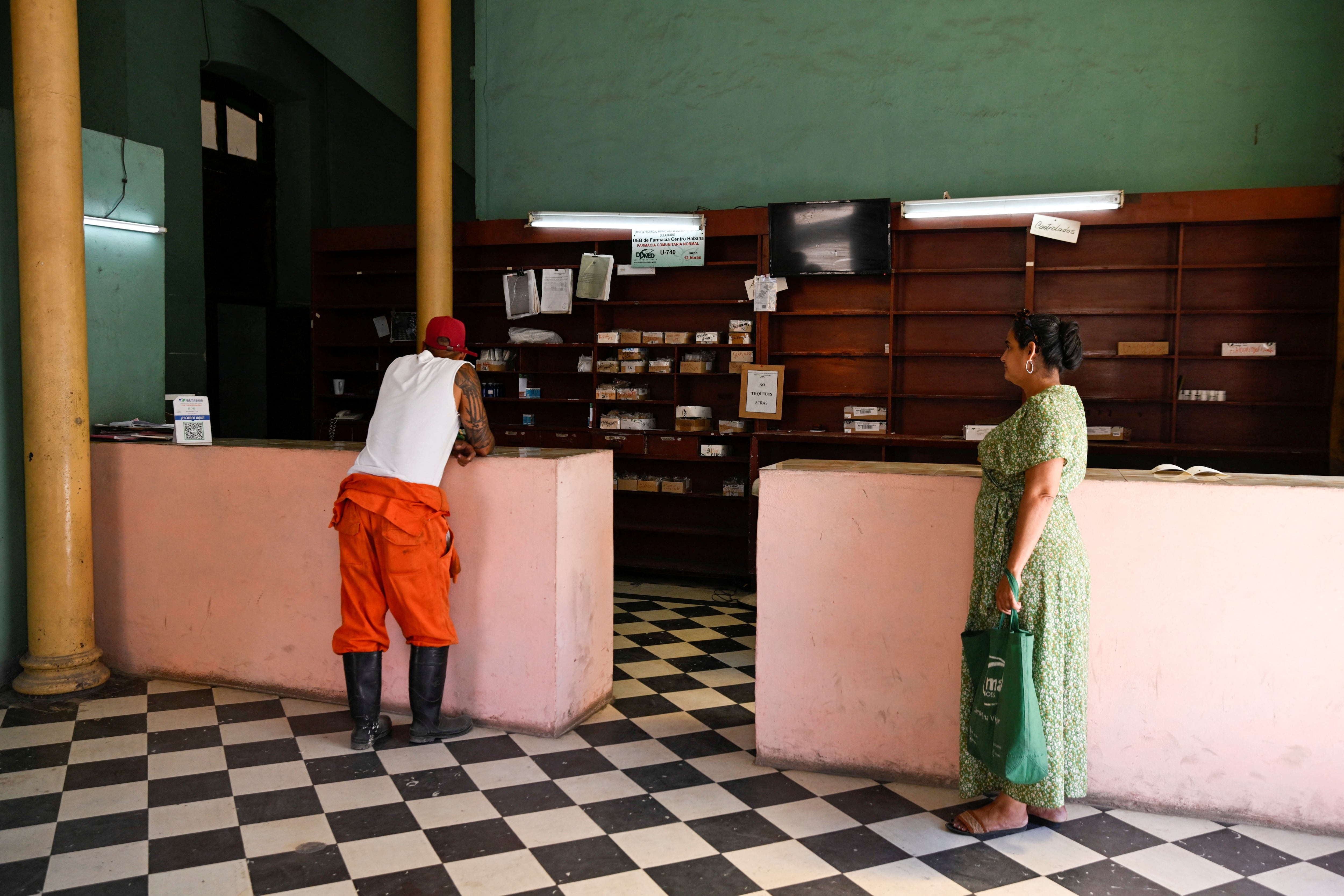 Imagen de marzo de 2026. Dos clientes esperan en una farmacia vacía, símbolo del colapso del sistema de salud cubano. REUTERS/Norlys Perez