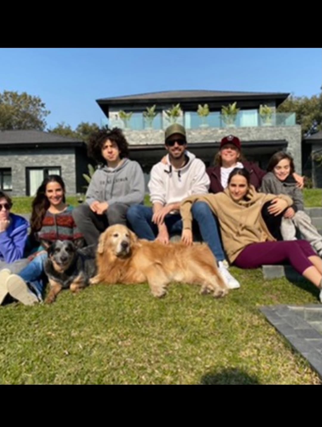 La familia: reunidos, sonrientes y acompañados por sus mascotas
