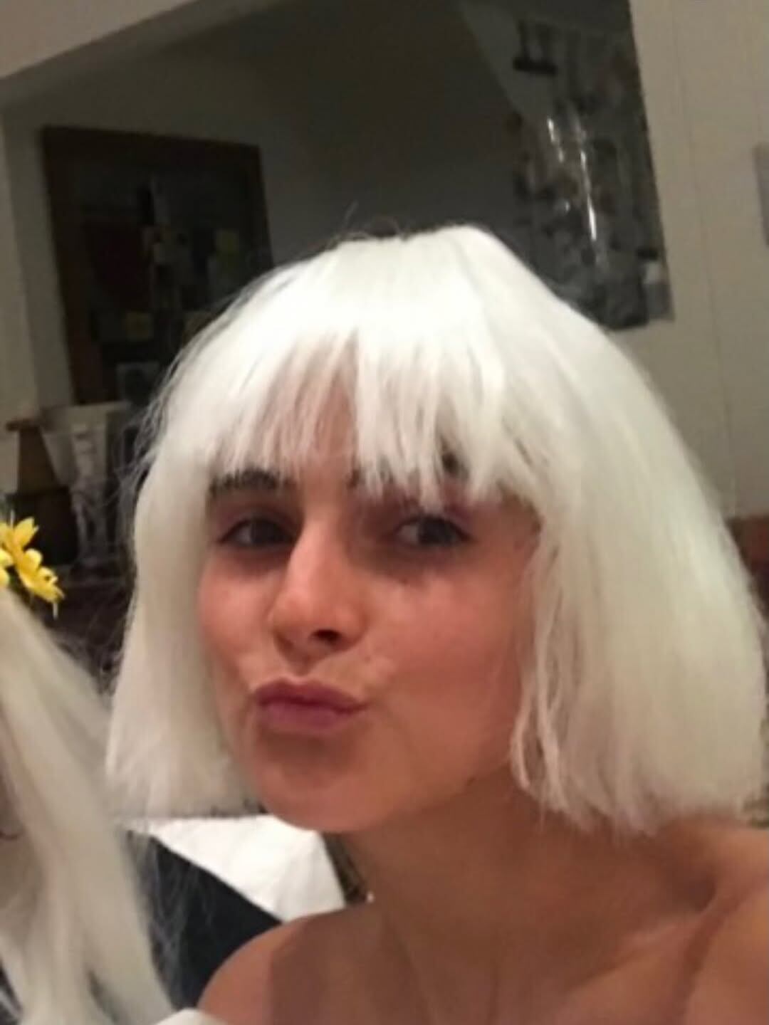 Con una divertida peluca, luciendo un corte y color llamativos