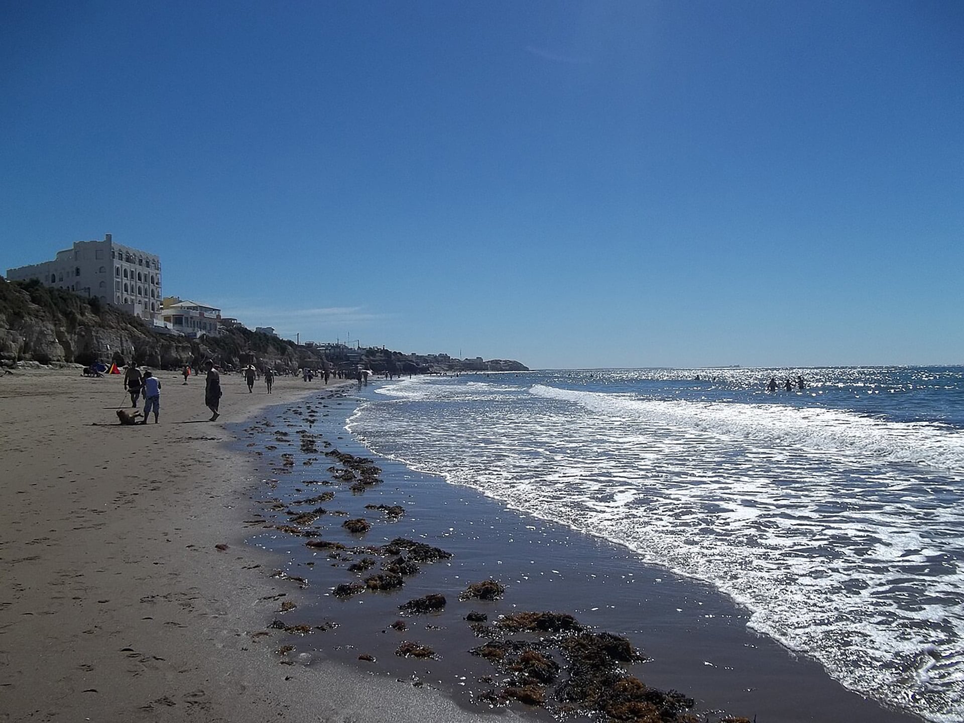 Turistas disfrutan de un día soleado en una playa del Golfo San Matías, una zona donde recientemente se avistaron más de 100 tiburones bacota