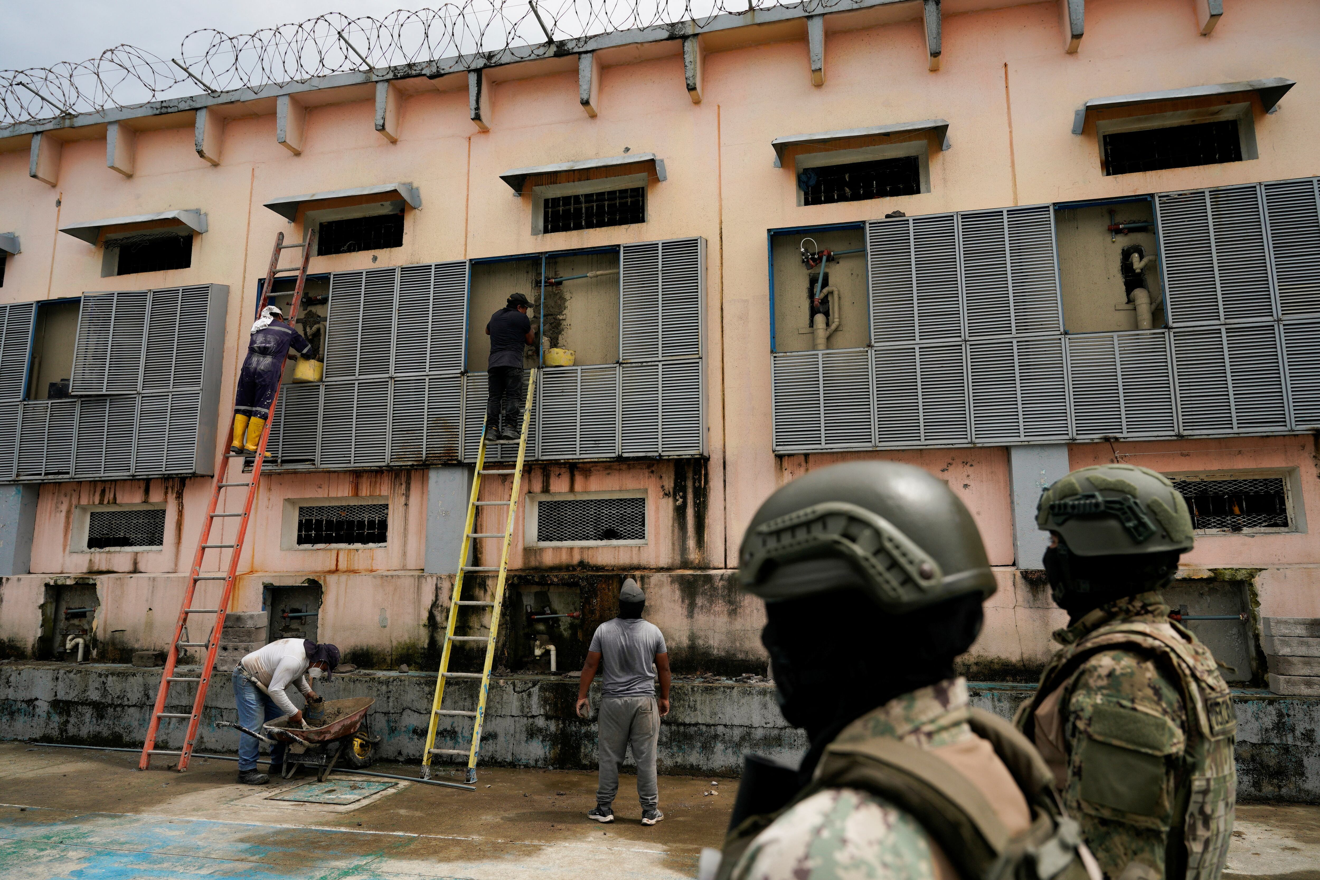 Miembros del ejército observan mientras los trabajadores realizan labores de mantenimiento en la Penitenciaría del Litoral, en medio de un brote de tuberculosis en el centro penitenciario, en Guayaquil, Ecuador, el 9 de abril de 2025. REUTERS/Santiago Arcos