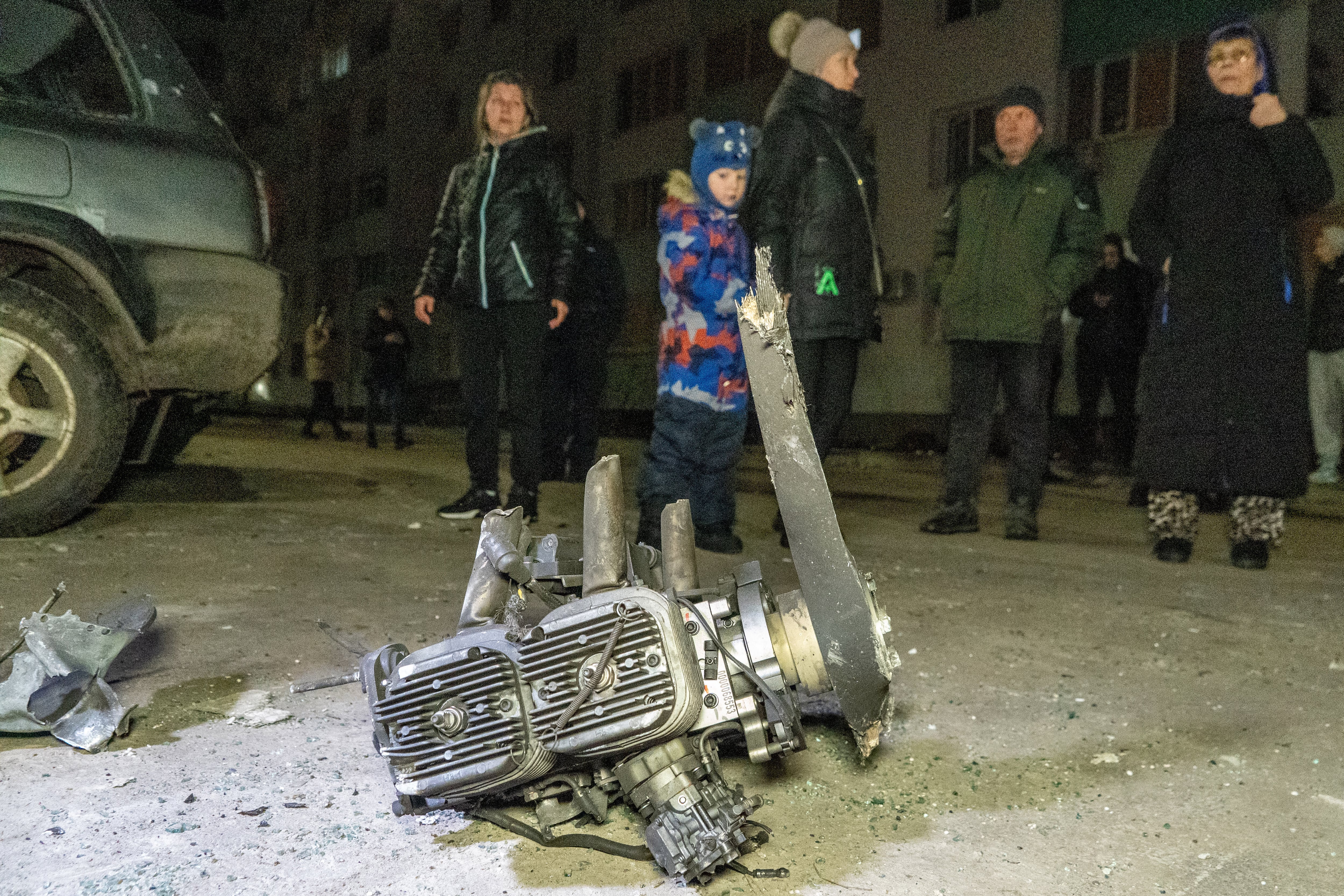 Gente mira fragmentos de un dron ruso que golpeó un vecindario residencial durante un ataque aéreo en Kharkiv, Ucrania, la noche del lunes 9 de marzo de 2026. (AP Foto/Andrii Marienko)