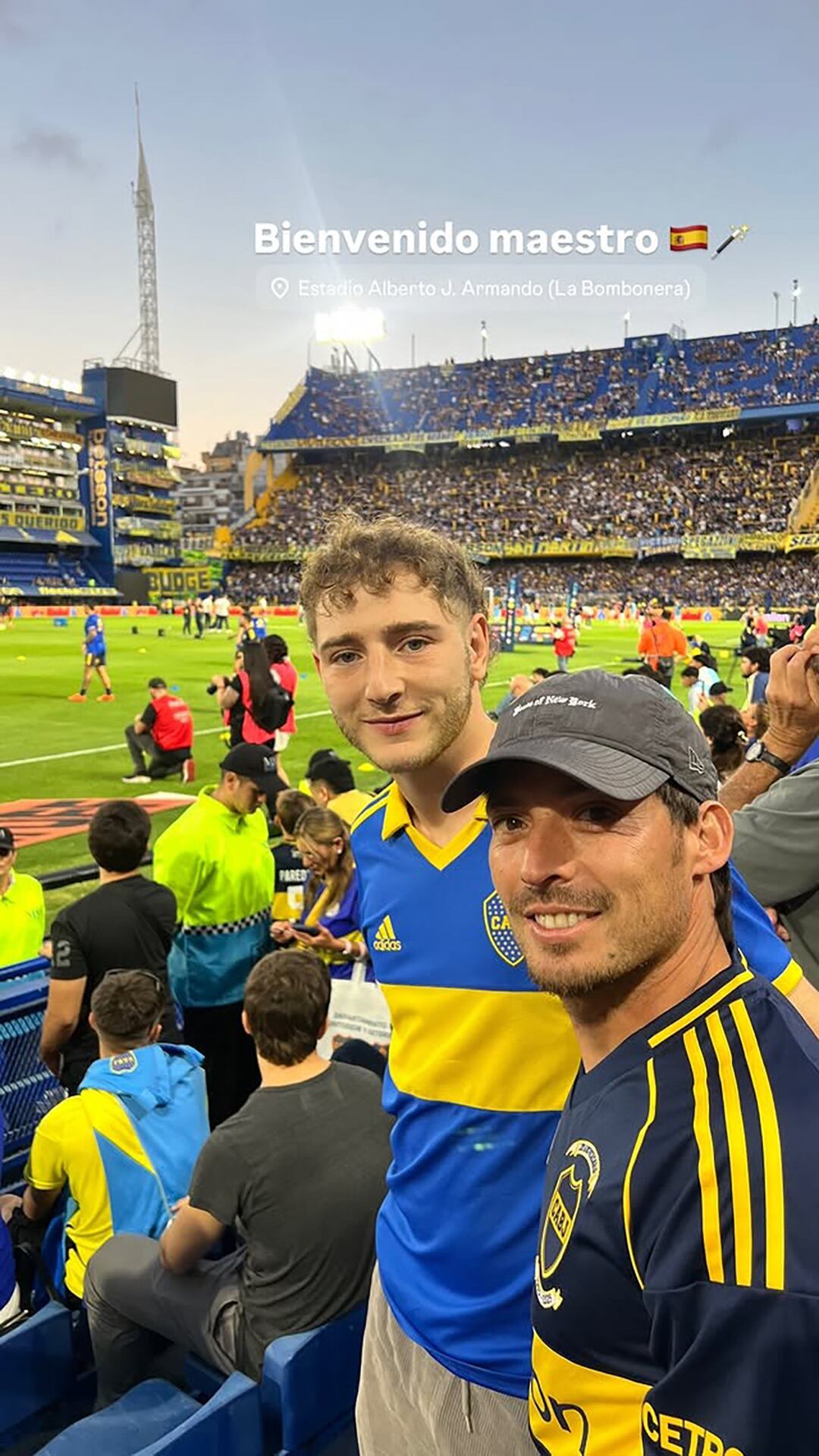 El exfutbolista español David Silva disfruta del ambiente en La Bombonera, sonriendo junto a un acompañante mientras luce una camiseta con los colores de Boca Juniors.