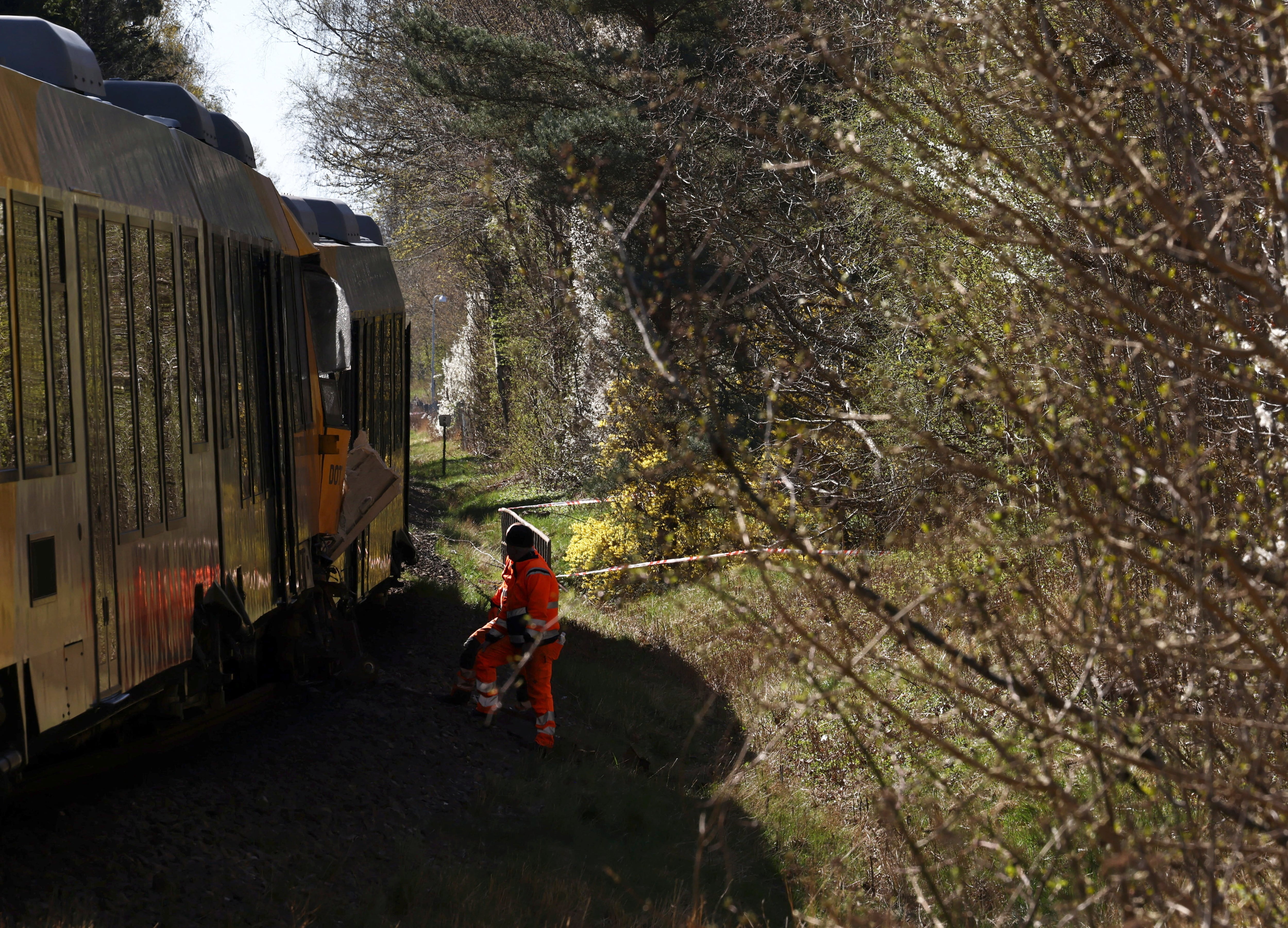 Un trabajador permanece en el lugar de una colisión entre dos trenes cerca de Hillerod, Dinamarca, el 23 de abril de 2026. REUTERS/Tom Little