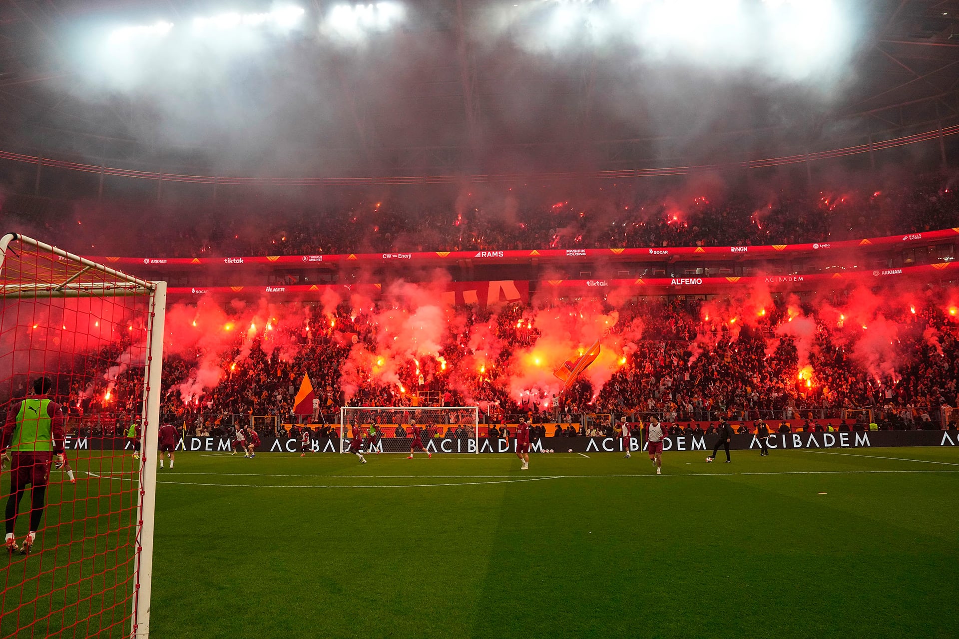 Miles de aficionados del Galatasaray llenan el estadio con bengalas rojas y humo, creando una atmósfera apasionada durante el entrenamiento abierto de su equipo en el estadio del Galatasaray. (@GalatasaraySK)