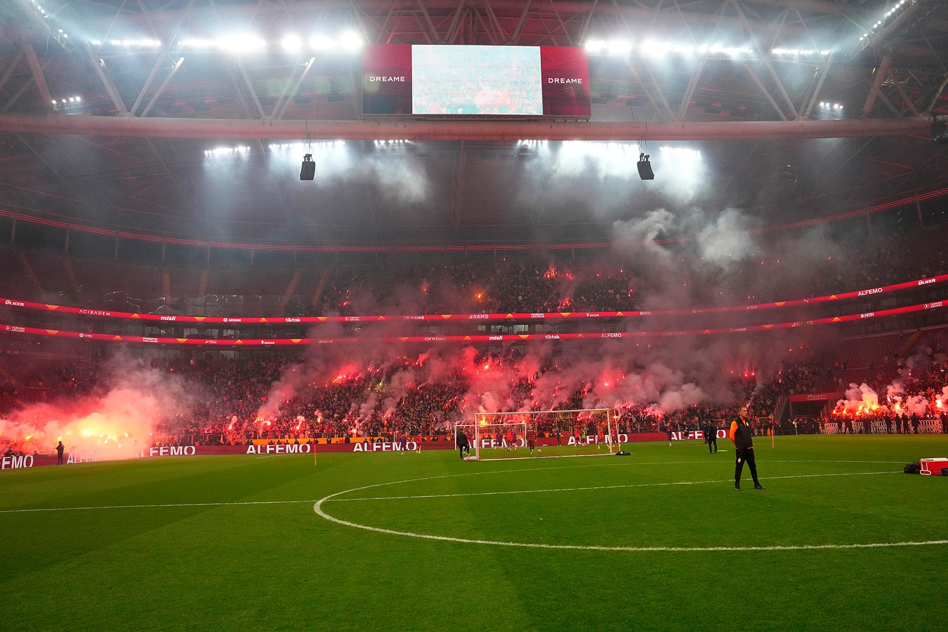 Miles de aficionados del Galatasaray crean una atmósfera espectacular con bengalas y humo rojo durante el entrenamiento abierto en su estadio. (@GalatasaraySK)