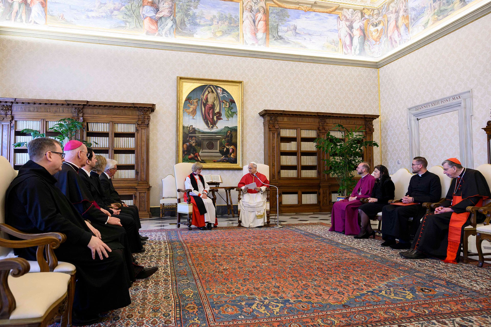 León XIV y Sarah Mullally se reúnen en el Vaticano, rodeados de clérigos, en un salón ricamente decorado. (AFP)