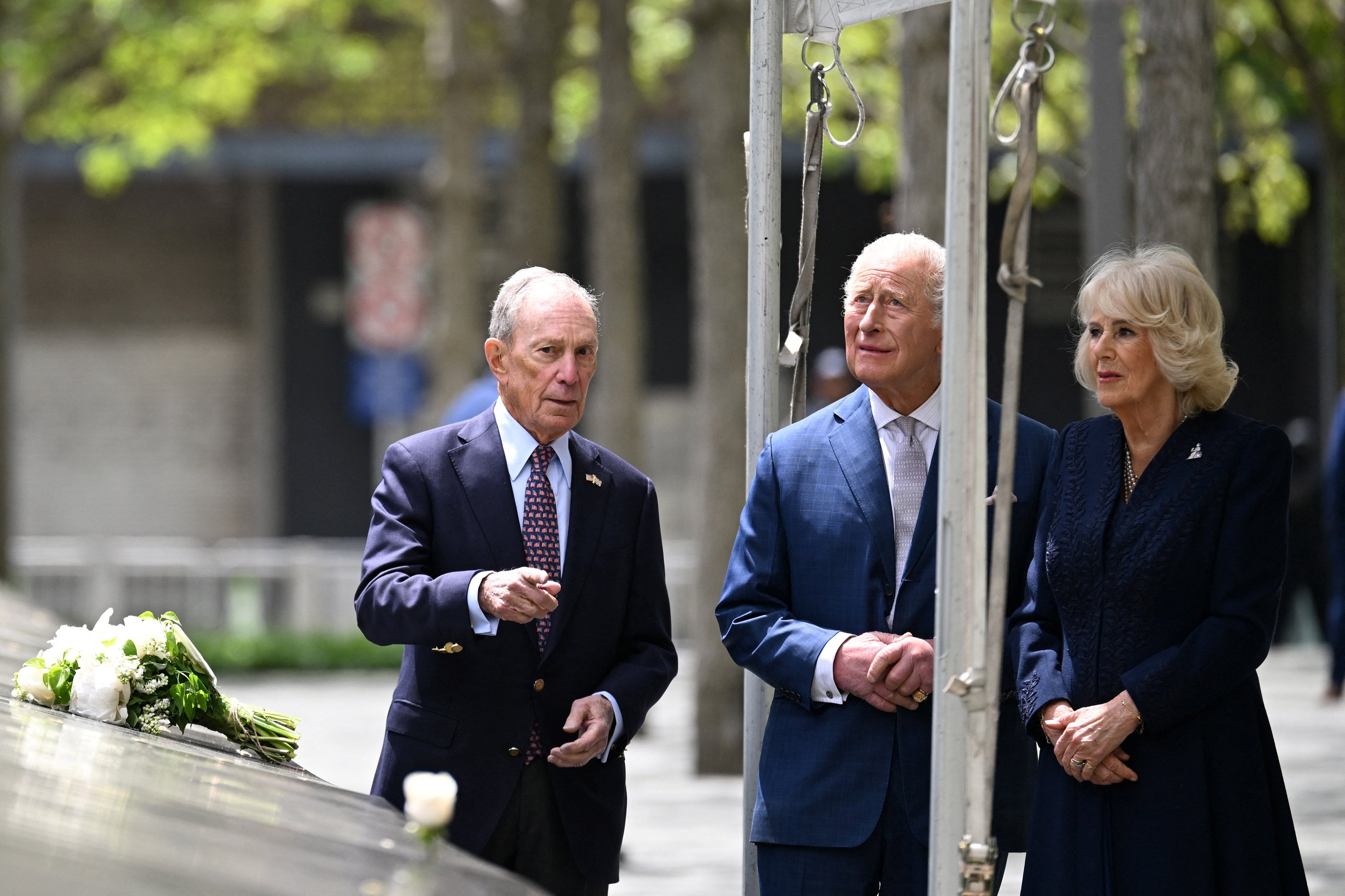Michael Bloomberg, presidente del Monumento Nacional del 11 de Septiembre, el rey Carlos III y la reina Camila de Gran Bretaña, aparecen tras depositar un ramo de flores en el borde de una de las piscinas del monumento, el 29 de abril de 2026 (Samir Hussein/REUTERS)