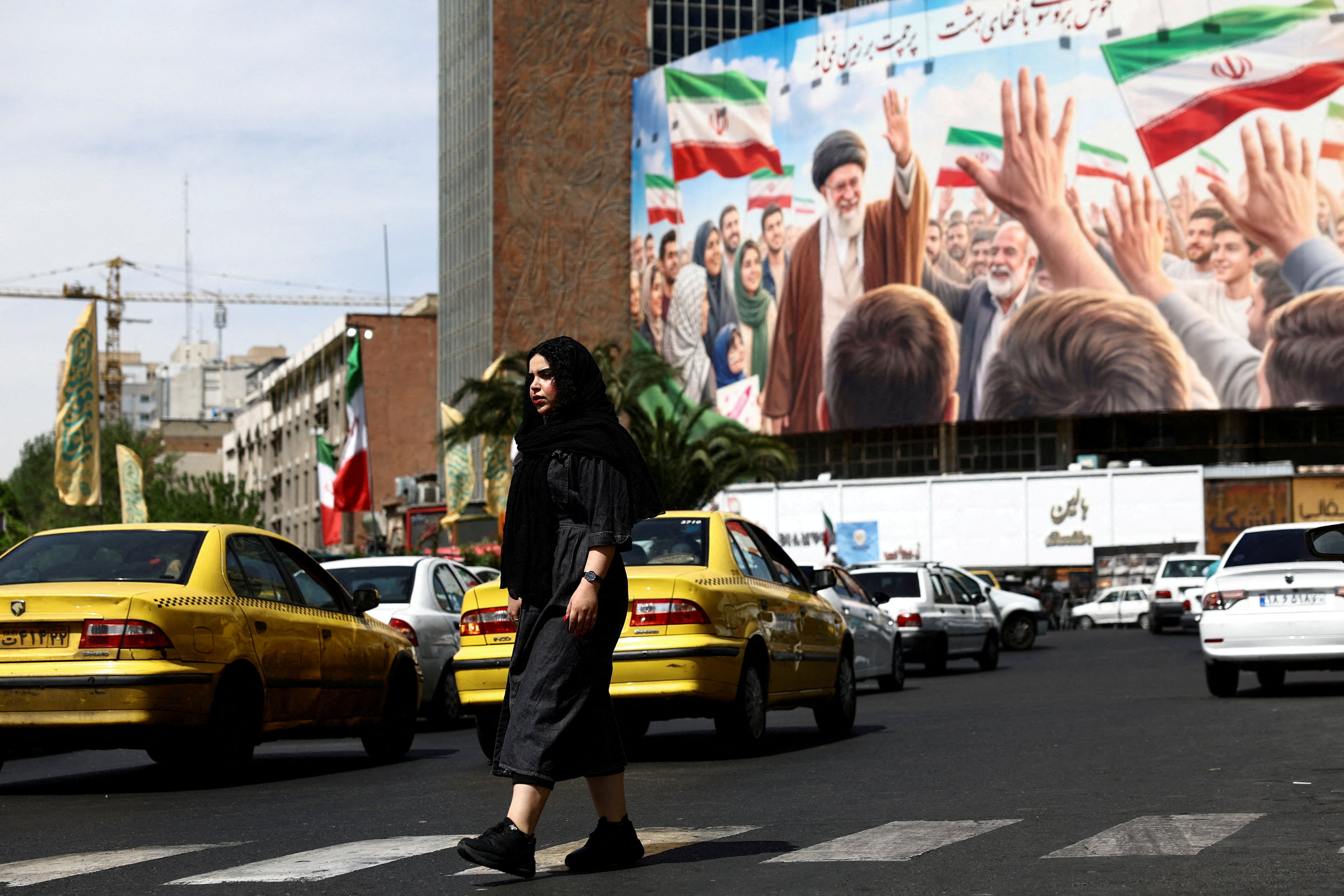 Una mujer pasa junto a una valla publicitaria que muestra una imagen del difunto Líder Supremo de Irán, el ayatolá Ali Khamenei, en Teherán, Irán, 27 de abril de 2026. (Majid Asgaripour/WANA vía REUTERS)