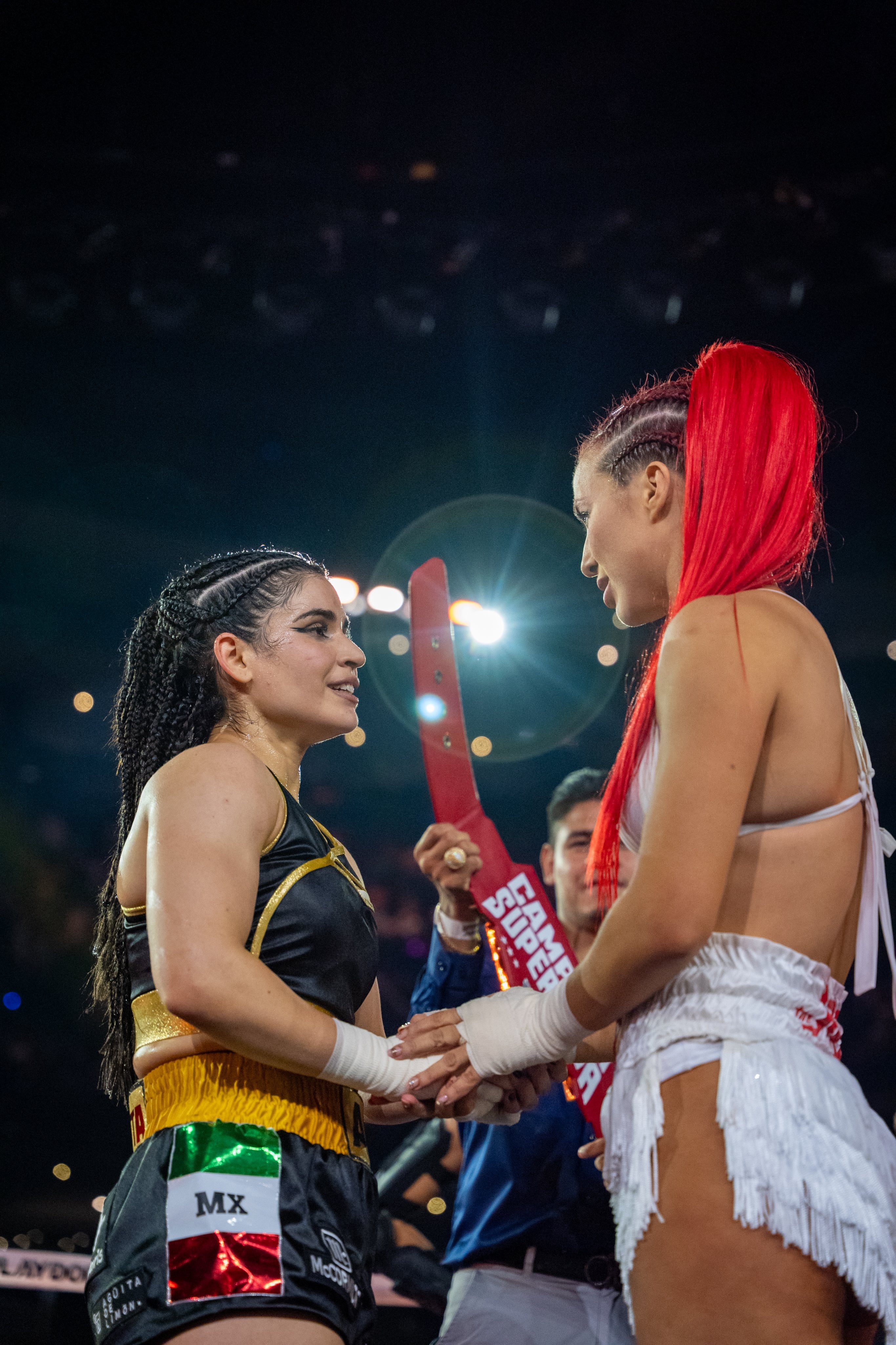 Las boxeadoras Flor Vigna y Alana Flores se miran fijamente mientras se saludan en el ring durante el evento Supernova Génesis México. ((Netflix))