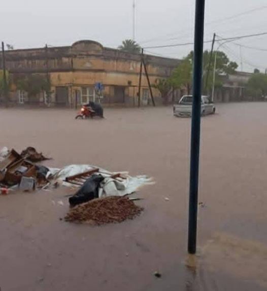 La imagen capta una calle anegada por la inundación. A lo lejos se observa a un motociclista y un coche intentando avanzar (Municipalidad de Los Juríes)