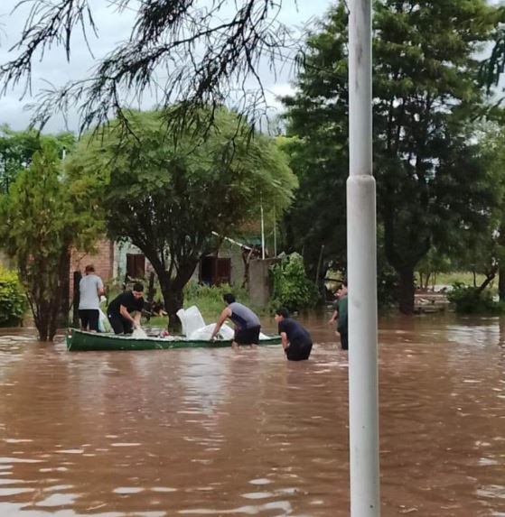 Vecinos utilizan una canoa para transportar bienes y asistir a otros en medio de las aguas crecidas. Las autoridades pusieron a disposición centros de evacuación (Municipalidad de Los Juríes)