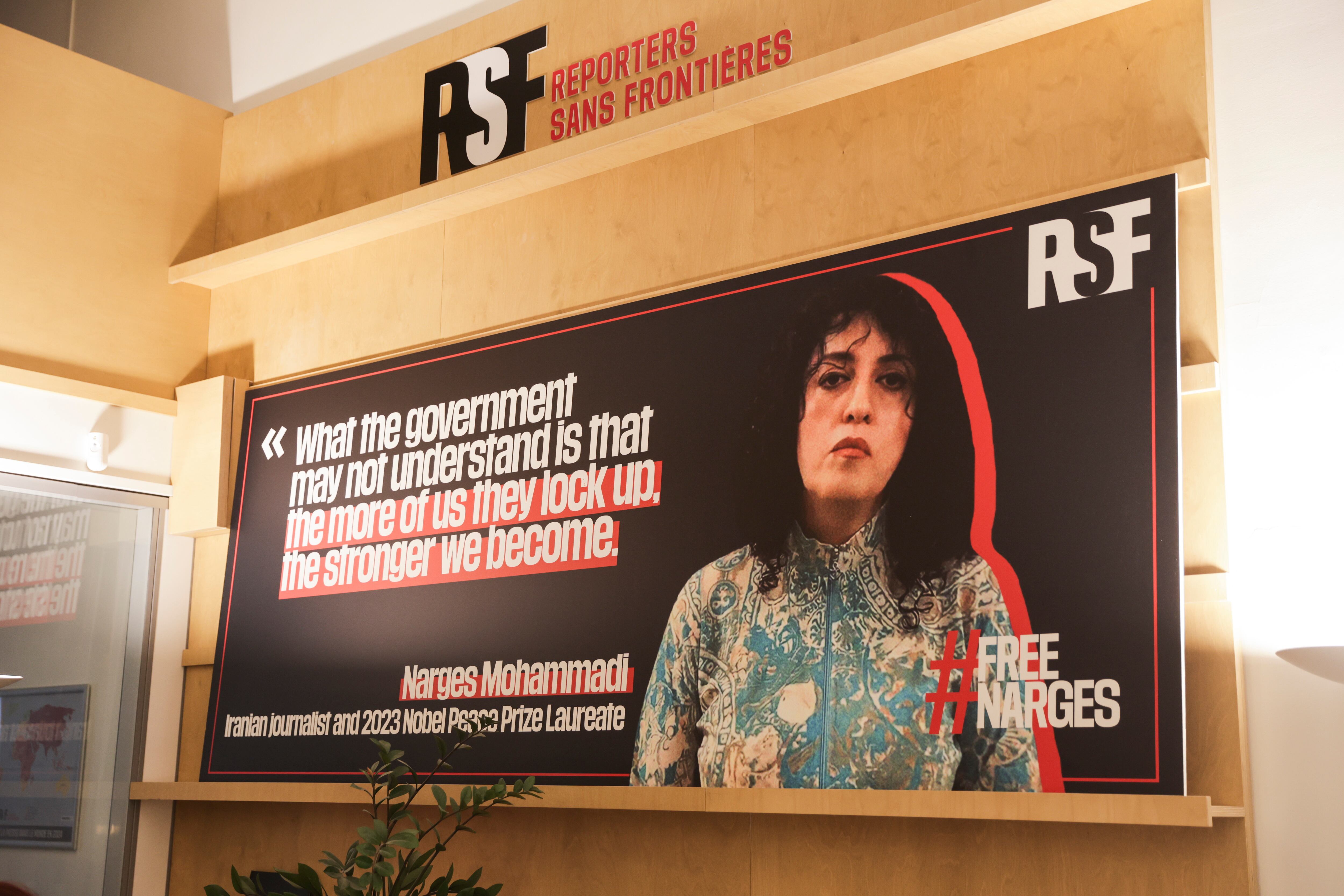 Un cartel muestra el retrato de la periodista iraní y Premio Nobel de la Paz Narges Mohammadi en la sede de Reporteros sin Fronteras en París, Francia (EFE)