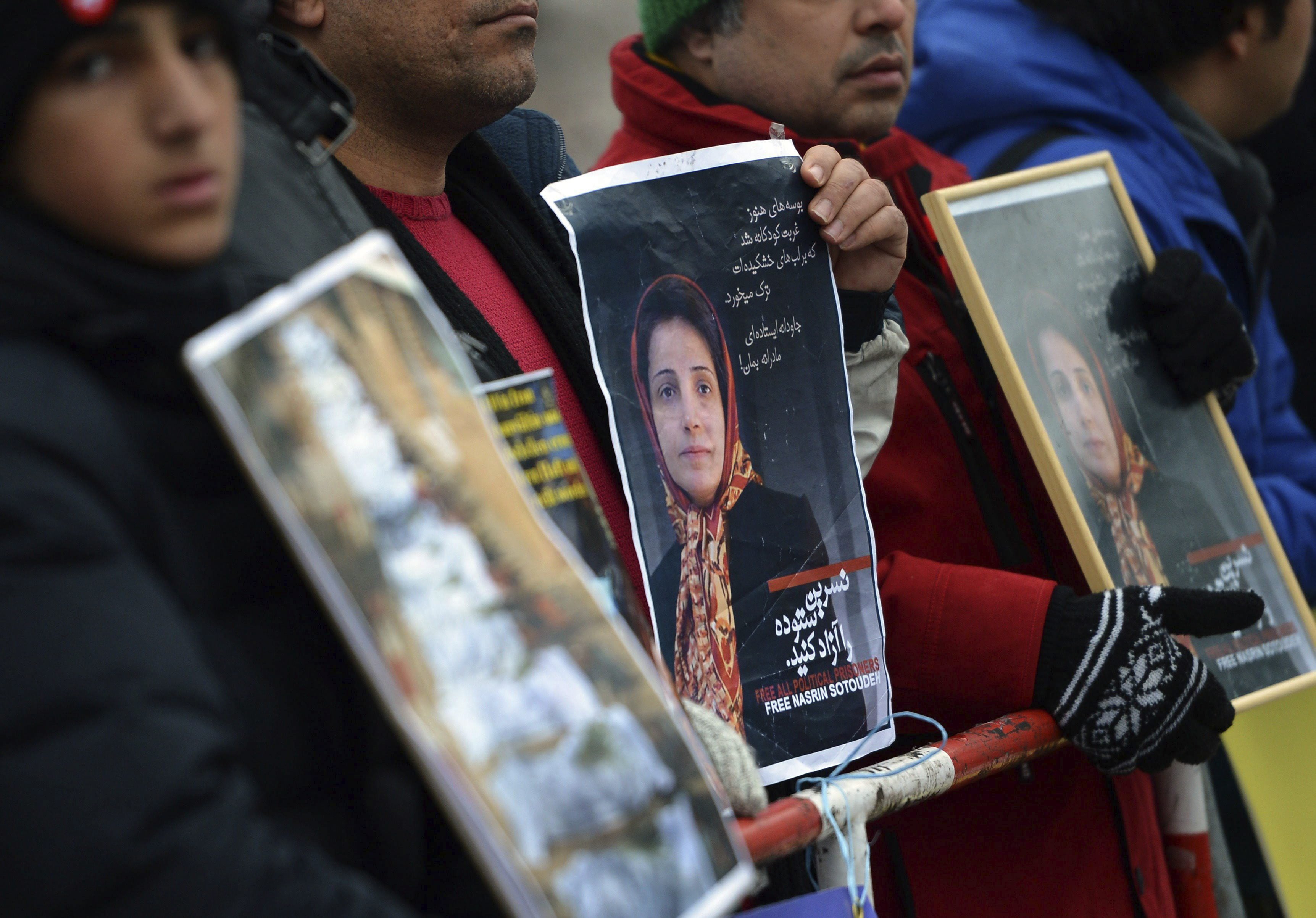 Manifestantes con fotos de la abogada y defensora de los derechos humanos iraní Nasrin Sotudeh ante la embajada de Irán en Berlín (EFE/Britta Pedersen)