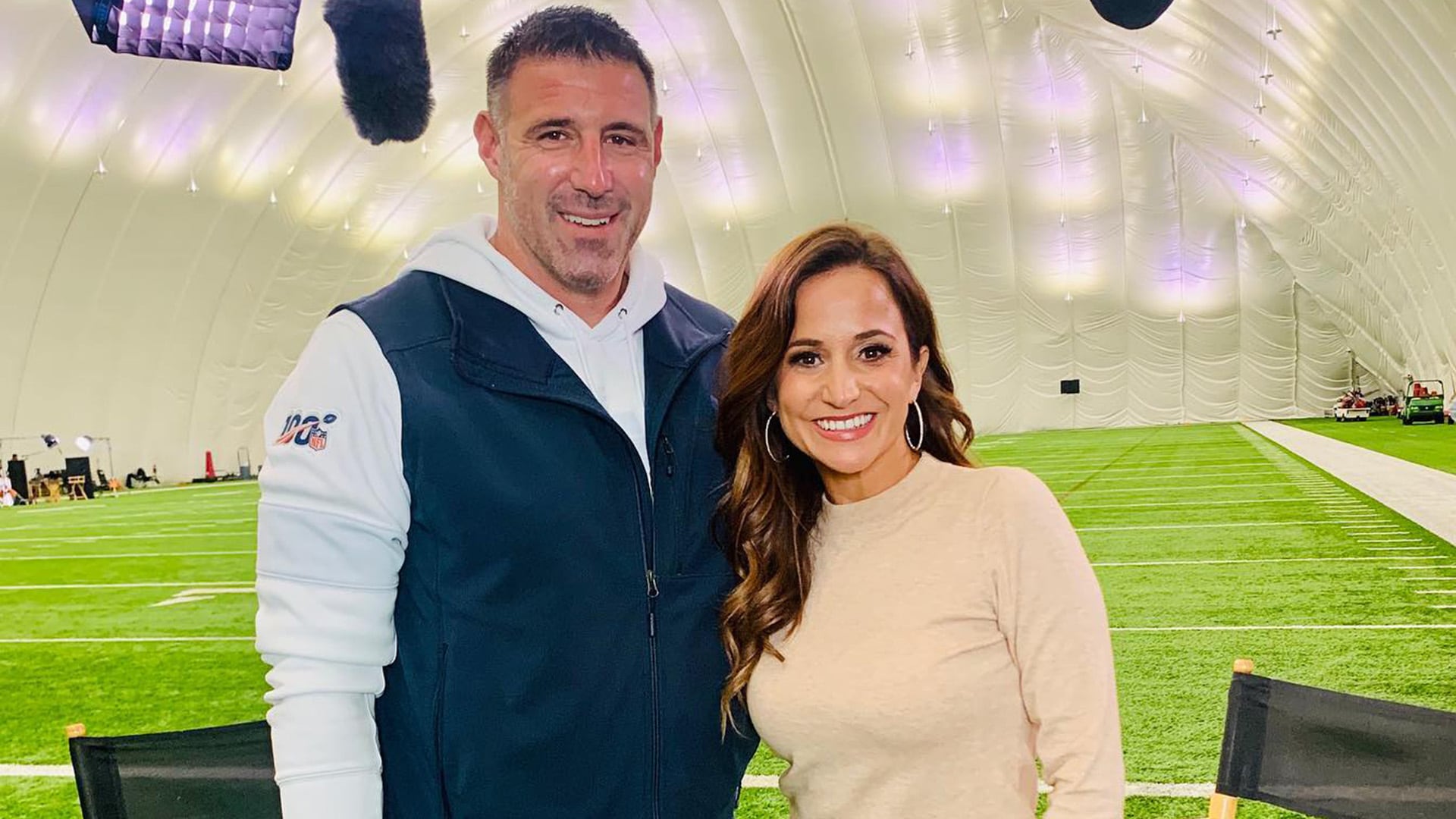 La periodista deportiva Dianna Russini posa sonriente junto al entrenador Mike Vrabel para una entrevista 