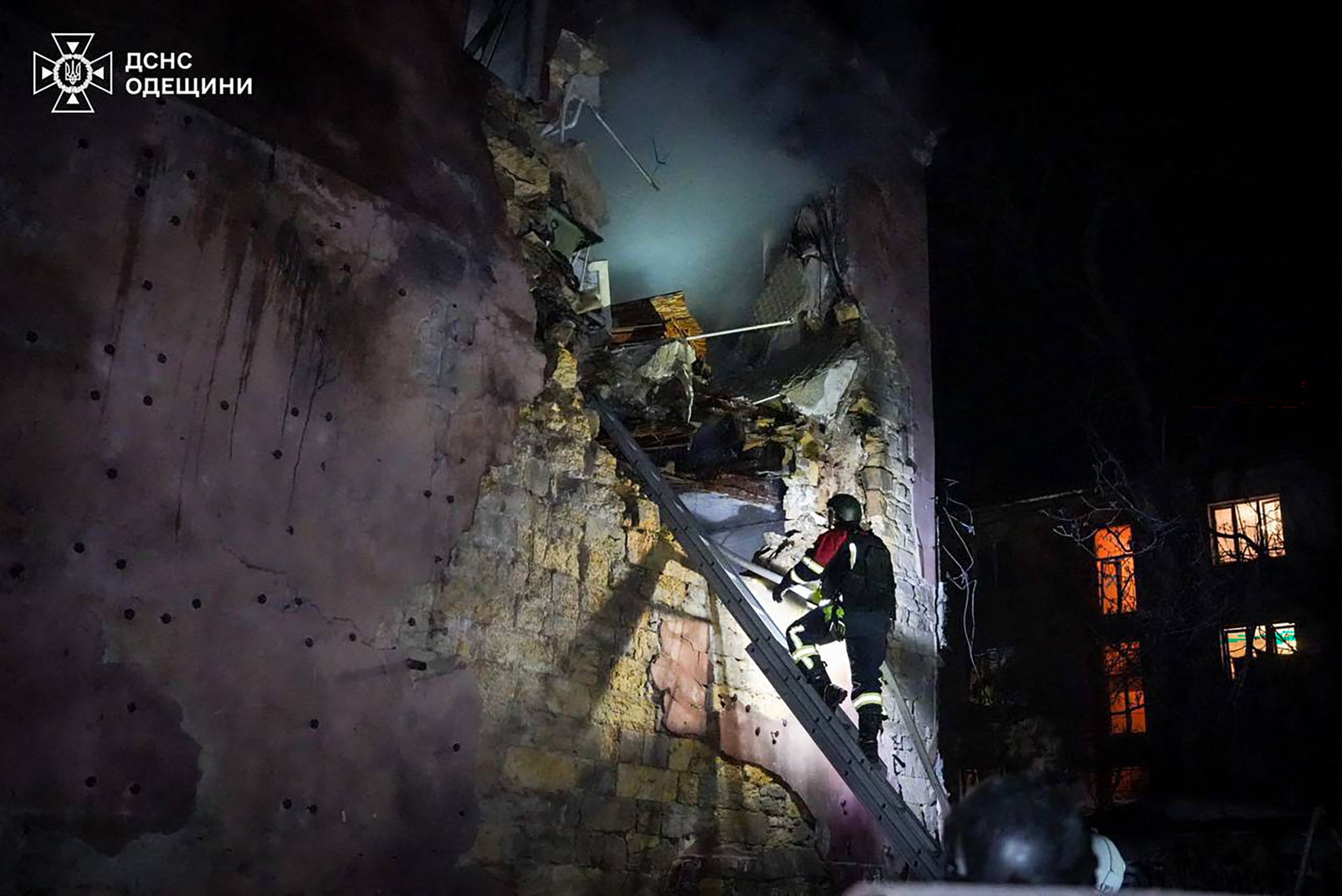 Un bombero subiendo una escalera en busca de supervivientes tras un ataque ruso a un edificio residencial en Odesa, en el contexto de la invasión rusa de Ucrania (AFP)