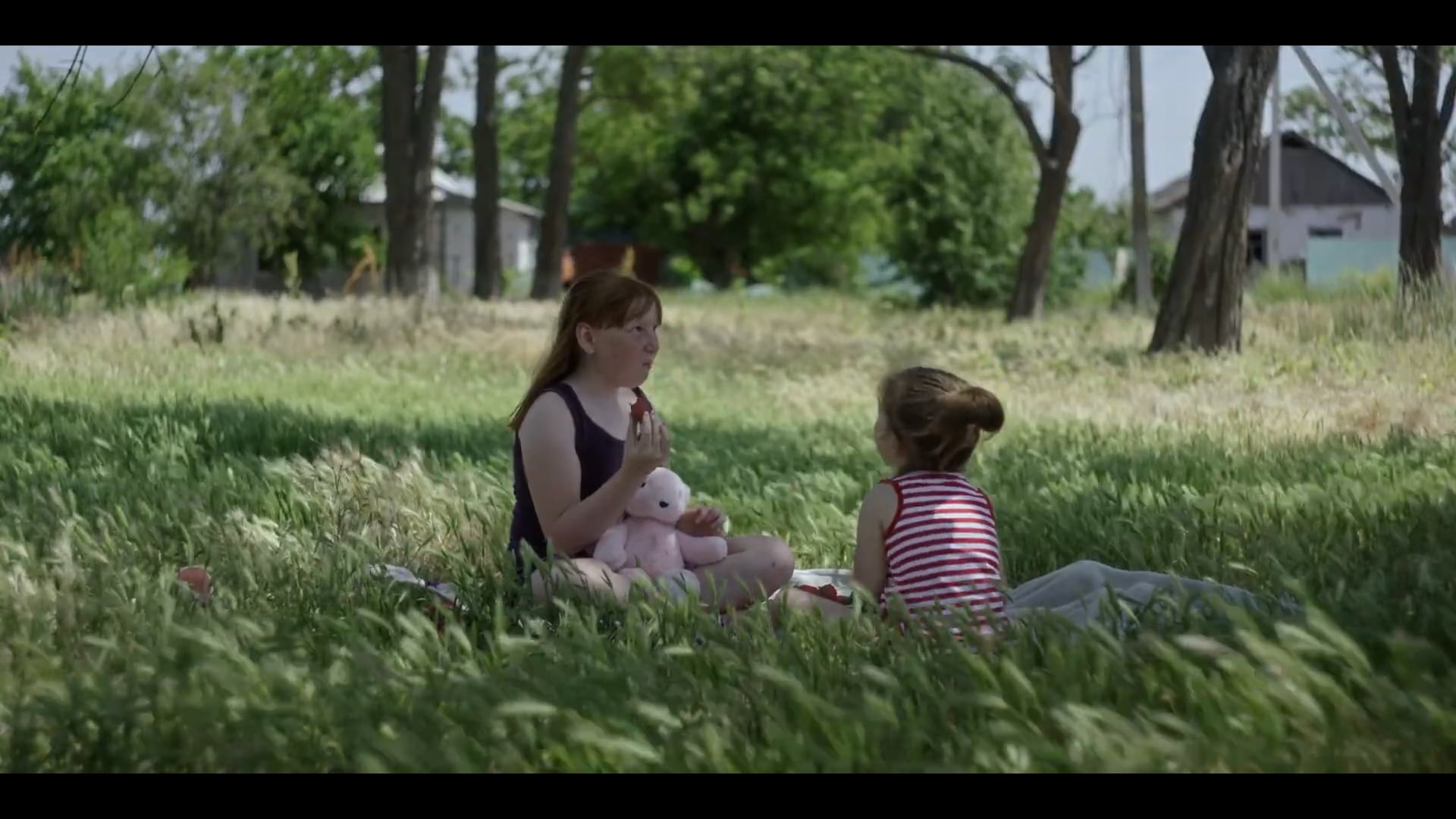 Dos niñas juegan en un prado en una escena de Militantropos. 