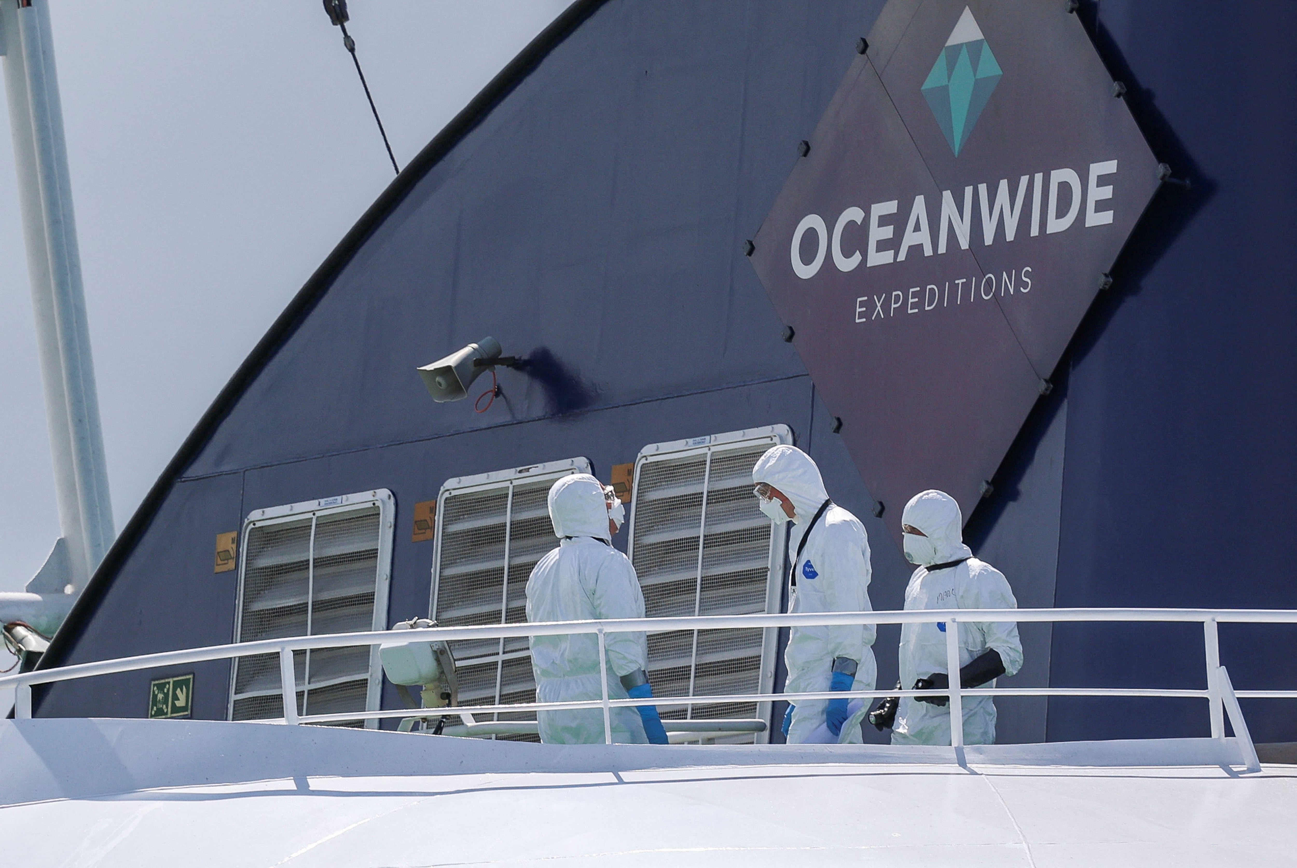 Personas con trajes de protección individual a bordo del crucero MV Hondius, afectado por un brote de hantavirus, tras su llegada al puerto de Róterdam, donde las autoridades neerlandesas preparan las medidas de cuarentena, en Róterdam, Países Bajos, el 18 de mayo de 2026. REUTERS/Yves Herman