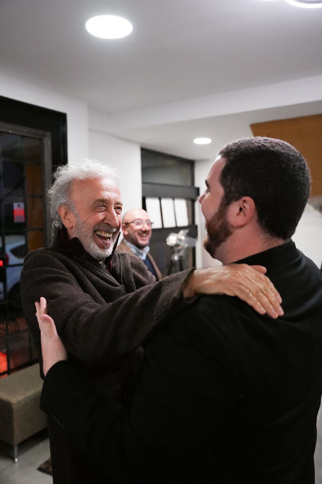 Eduardo Blanco abraza a Gastón Cocchiarale con una carcajada, celebrando la inauguración del Teatro Almagna