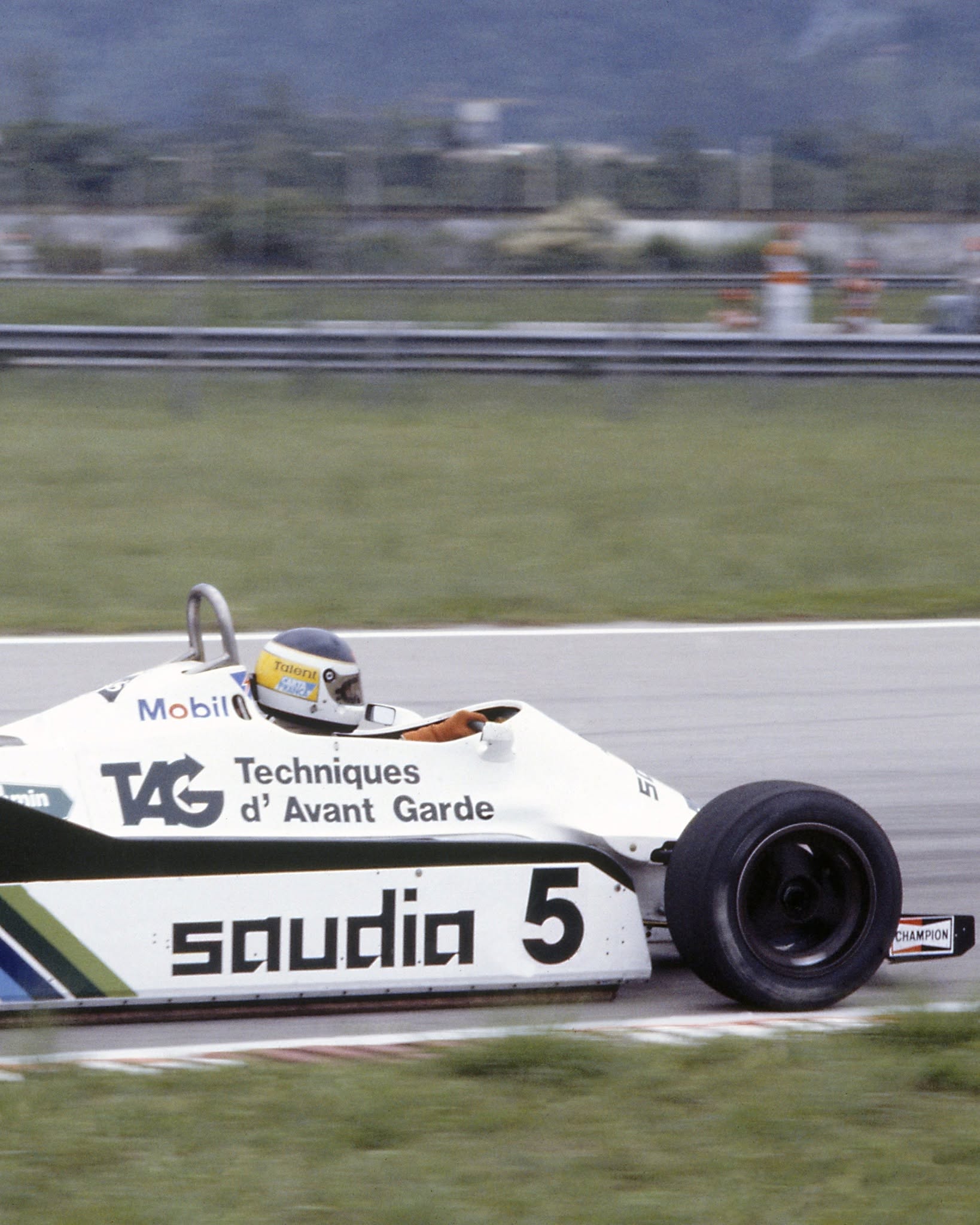 El legendario piloto argentino Carlos Reutemann compite a bordo de su Williams FW07/08 en una carrera de Fórmula 1, evocando la rica historia del automovilismo argentino.