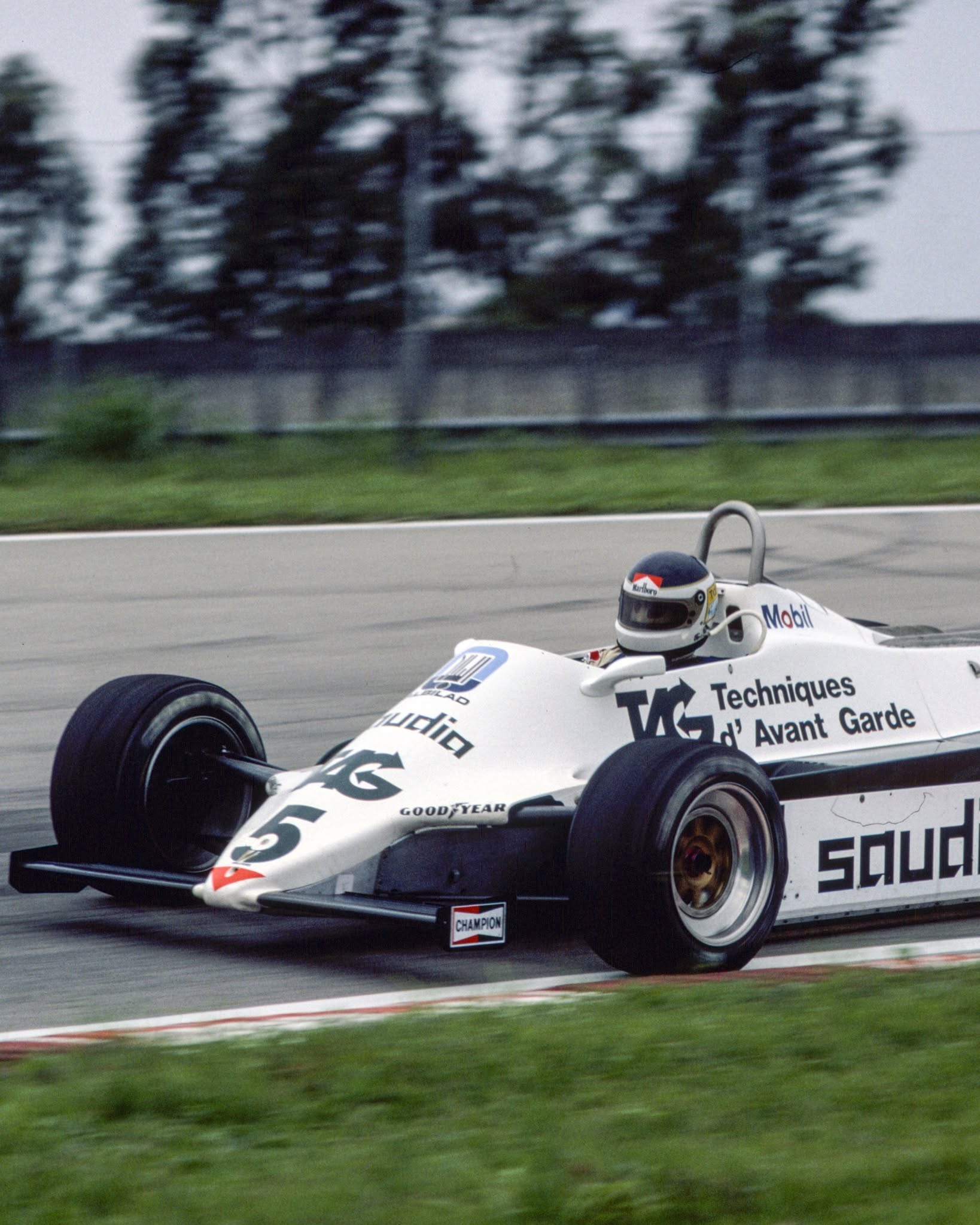 El legendario piloto argentino Carlos Reutemann en acción, conduciendo su icónico monoplaza número 5 durante una carrera de Fórmula 1.