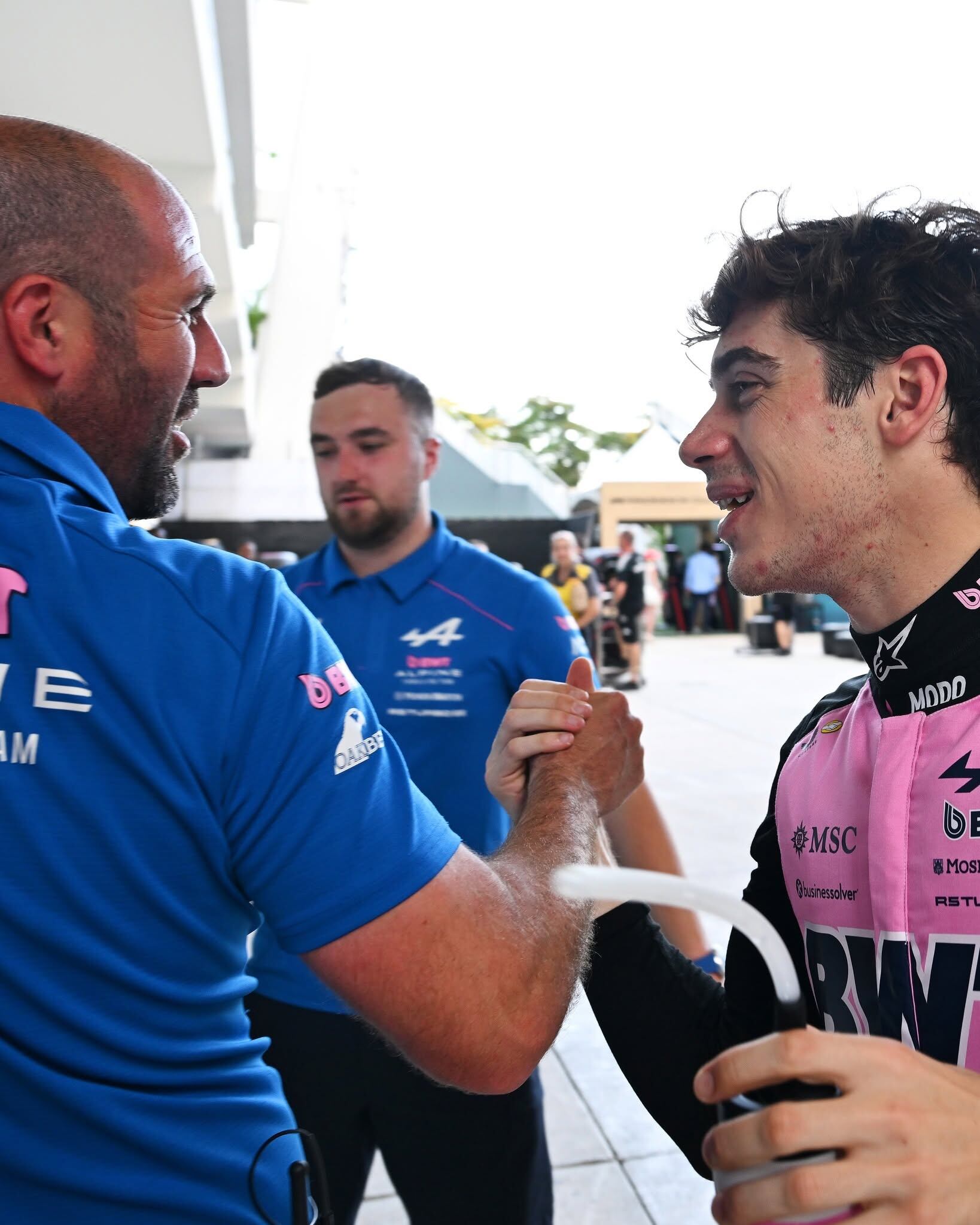 El piloto argentino Franco Colapinto celebra su clasificación para el Gran Premio de Miami de Fórmula 1 con un miembro de su equipo.