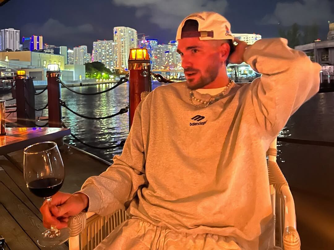 Rodrigo De Paul, en una noche en lo que parece ser Miami: vino tinto, skyline y buzo Balenciaga
