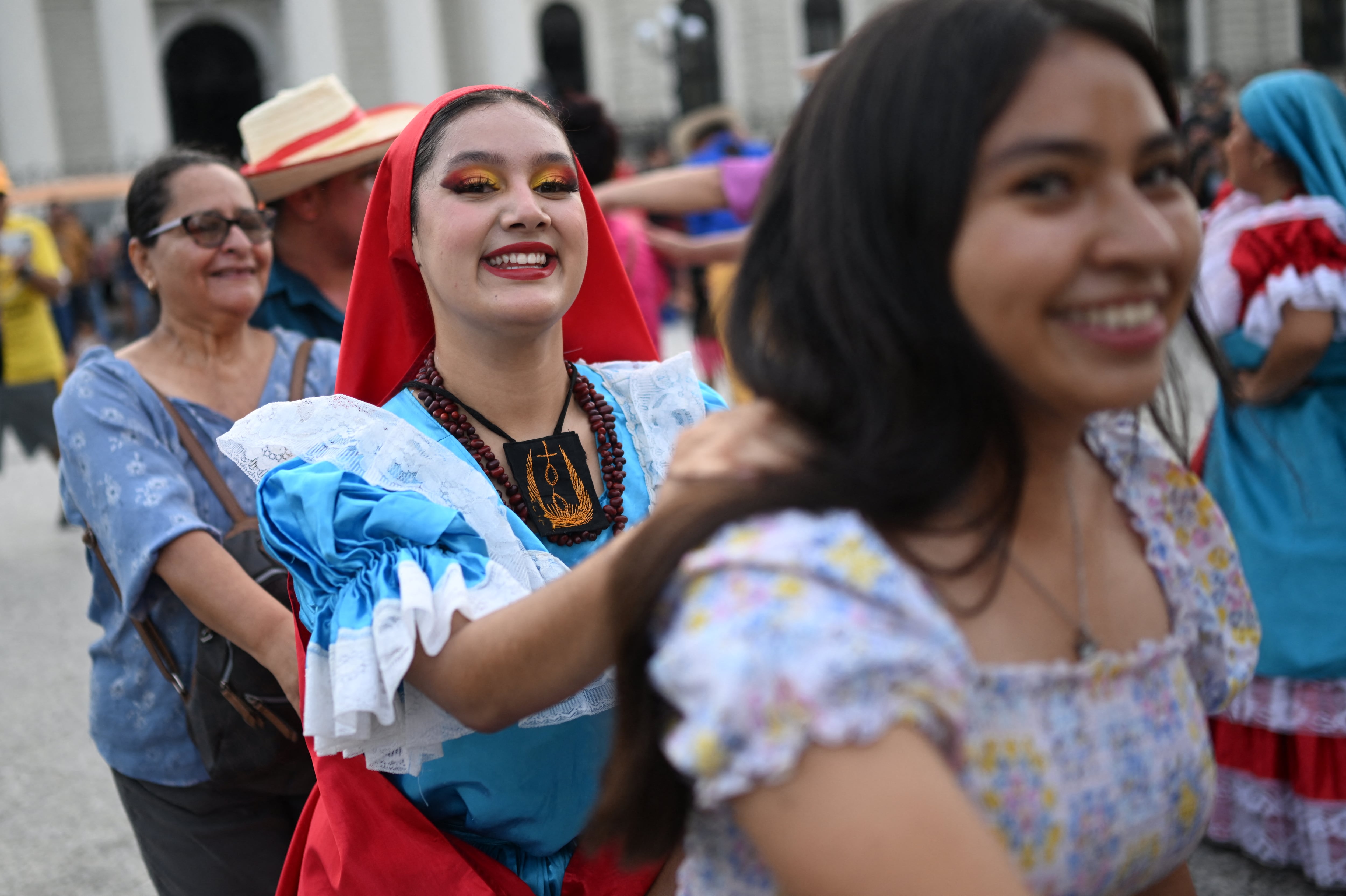 Bailarines folclóricos interactúan con turistas en el centro histórico de San Salvador, El Salvador, el 7 de mayo de 2026. (Foto de Marvin RECINOS / AFP)