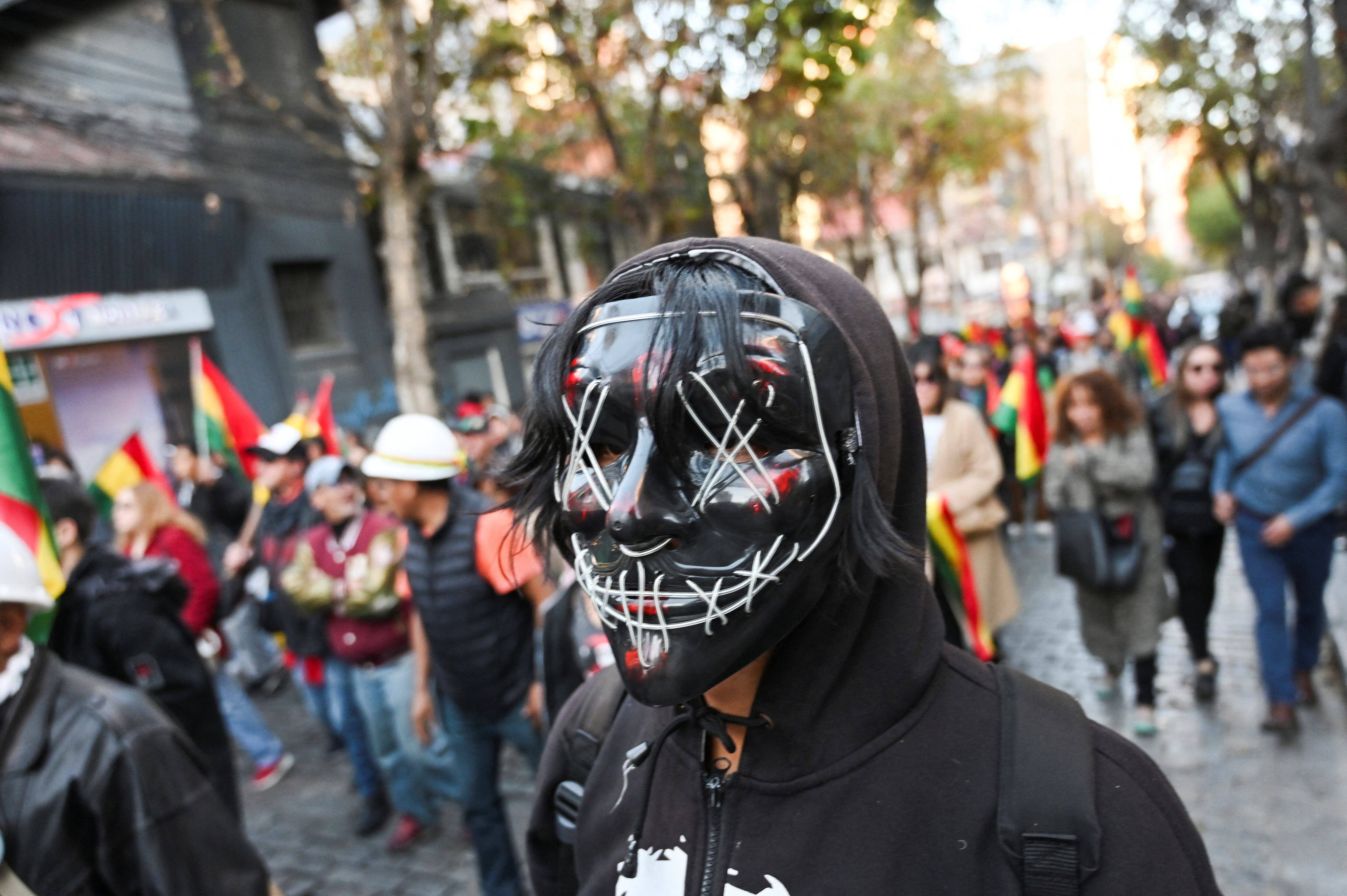 Una persona lleva una mascarilla durante una marcha en defensa de la democracia y contra los cortes de carretera y las medidas de presión, mientras continúan las protestas que exigen la dimisión del presidente de Bolivia, Rodrigo Paz, y se agrava la crisis económica y del combustible en el país, en La Paz, Bolivia, el 20 de mayo de 2026 (REUTERS/Claudia Morales)