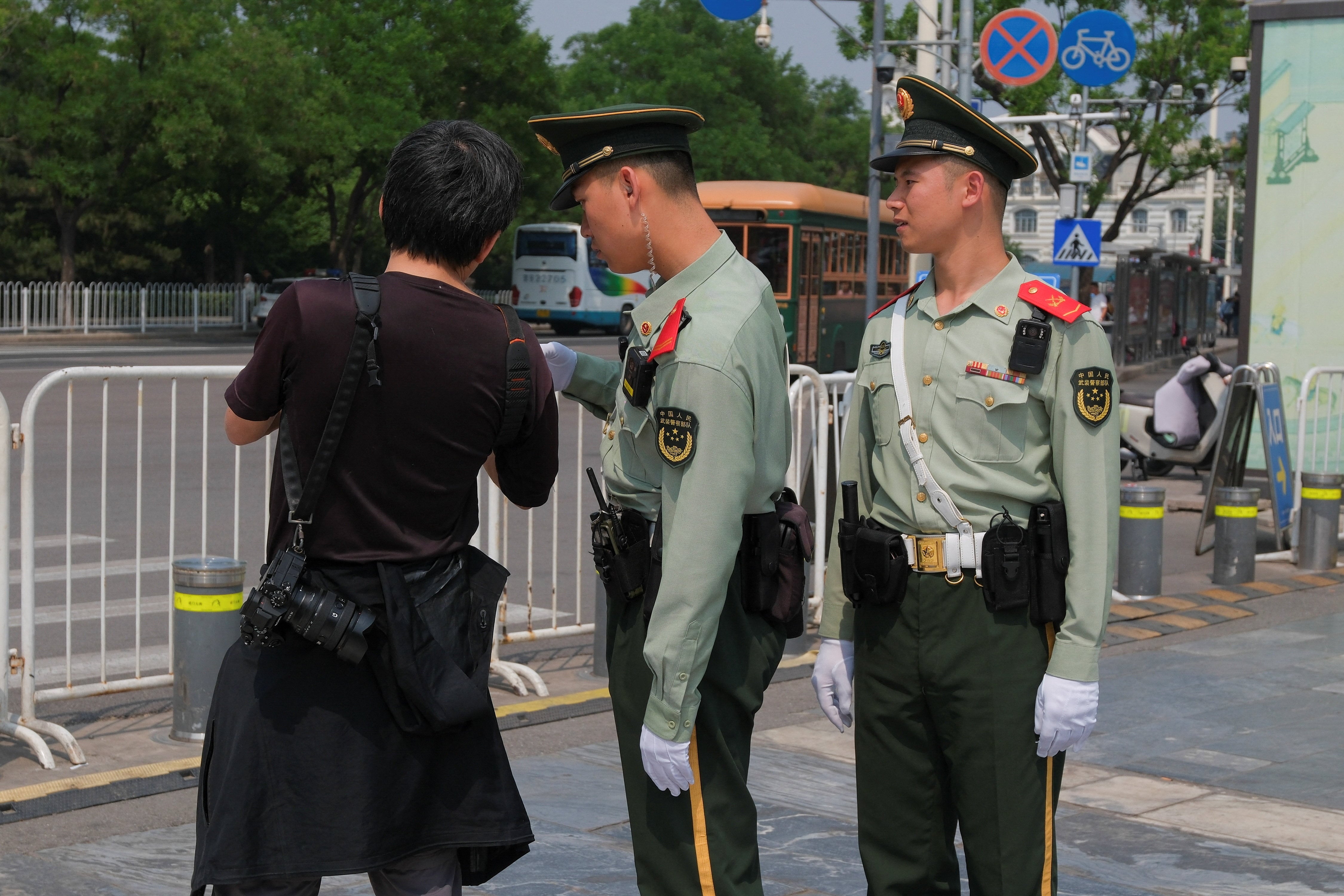 Agentes de la policía paramilitar revisan la cámara de un fotógrafo antes de la visita del presidente de Estados Unidos, Donald Trump, a China, en Pekín, China, el 13 de mayo de 2026 (Reuters)