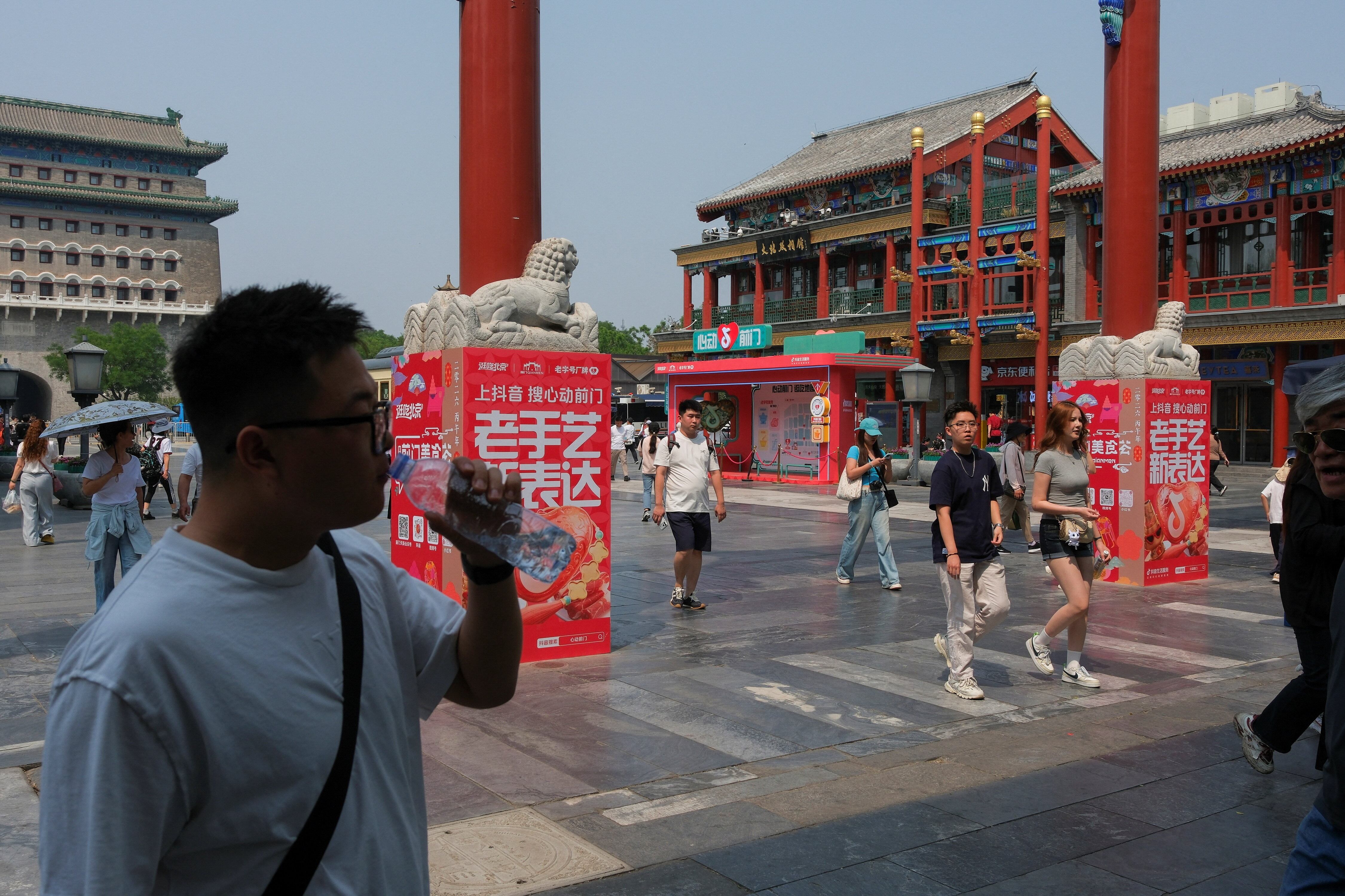 Personas caminan por la calle peatonal de Qianmen, antes de la visita del presidente de Estados Unidos, Donald Trump, a China, en Pekín, China, el 13 de mayo de 2026 (Reuters)