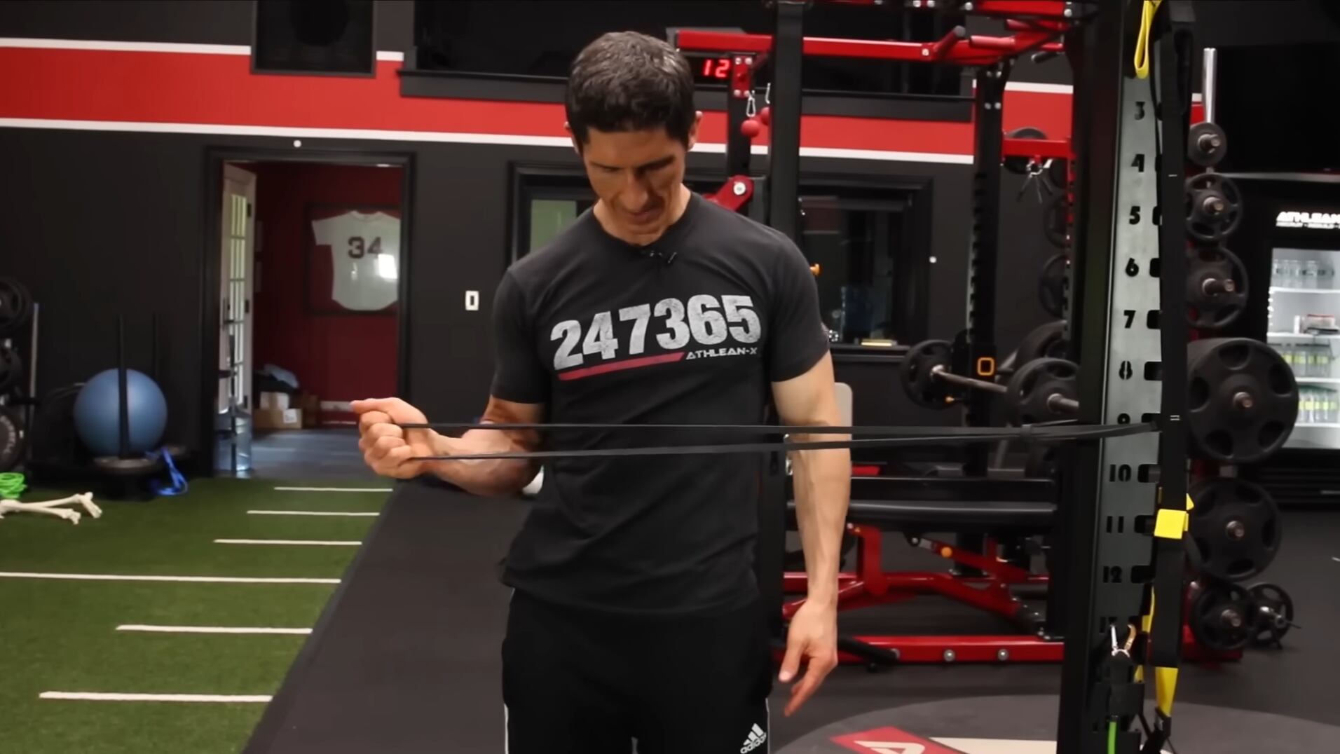 El trabajo específico con bandas elásticas para rotadores de cadera y hombro es fundamental para evitar desviaciones articulares y fortalecer puntos débiles (Captura de video: YouTube/@athleanx )