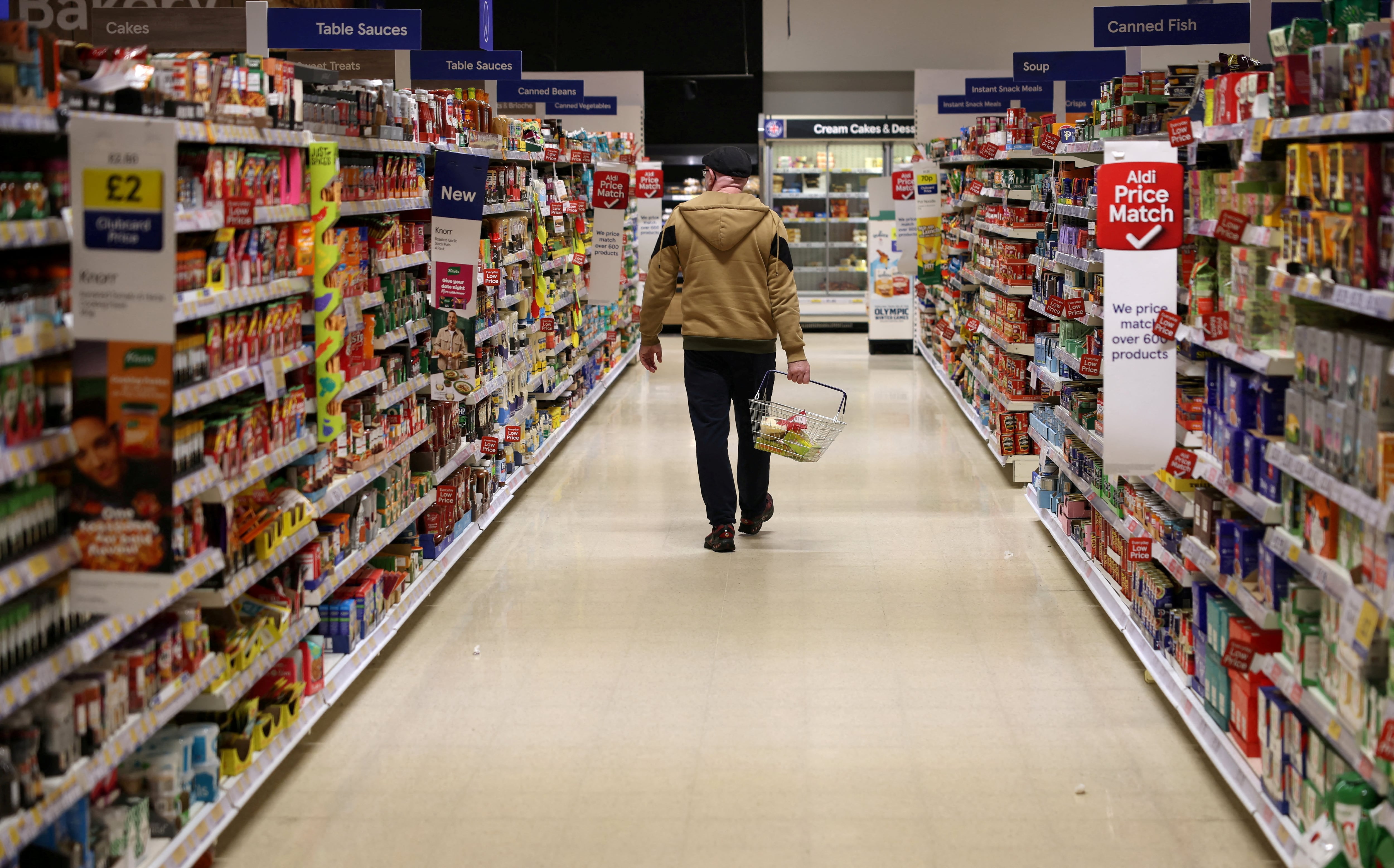 Un hombre camina a lo largo de un pasillo dentro de un supermercado Tesco REUTERS/Phil Noble