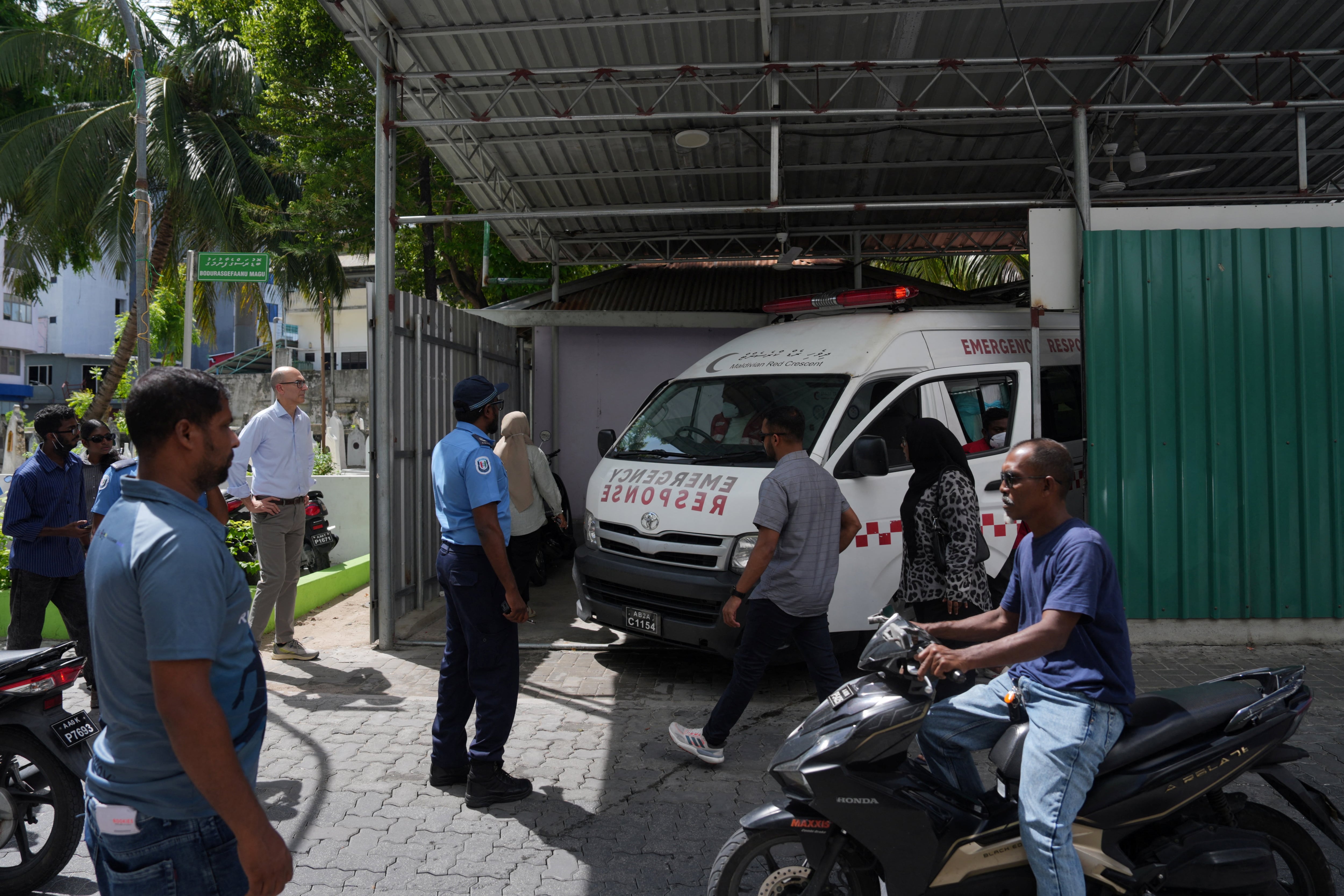 Damiano Francovigh, embajador de Italia en Sri Lanka y embajador no residente en Maldivas, y personal médico observan una ambulancia que transporta los cuerpos de los dos últimos buceadores italianos que fallecieron en un accidente en cuevas submarinas, a las afueras de una morgue en Malé, Maldivas, el 20 de mayo de 2026. REUTERS/Thilina Kaluthotage