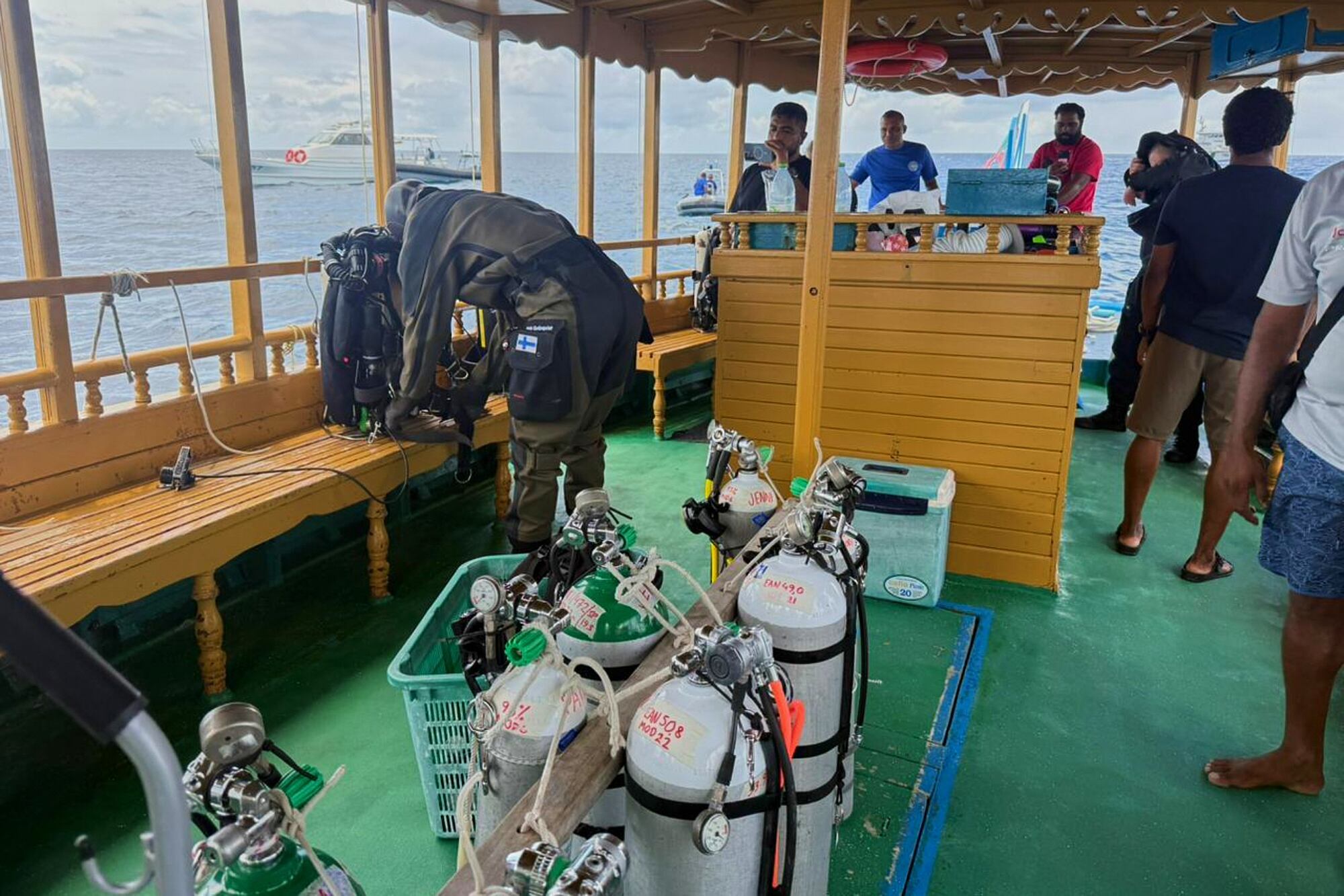 En esta fotografía distribuida por la División de Prensa de la Presidencia de Maldivas, un buzo finlandés, a la izquierda, se prepara para intentar recuperar los cuerpos de dos de los cuatro italianos que fallecieron en las profundidades de una cueva submarina en un atolón a principios de este mes, en la isla Alimathaa, en el atolón Vaavu, Maldivas, el martes 19 de mayo de 2026. (División de Prensa de la Presidencia de Maldivas vía AP)