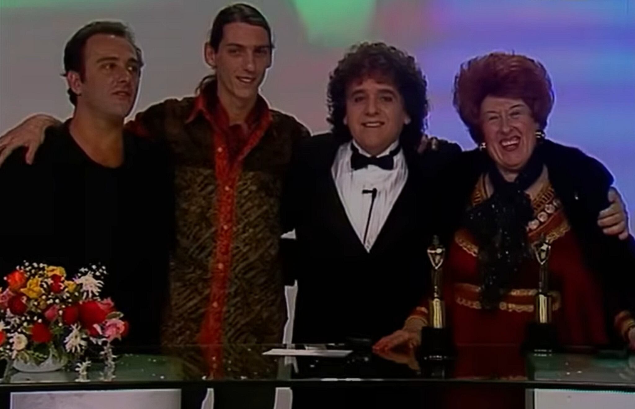 Alejandro Urdapilleta, Humberto Tortonese, Antonio Gasalla y Nelly Lainez posan sonrientes con premios sobre una mesa, celebrando sus logros en el espectáculo.