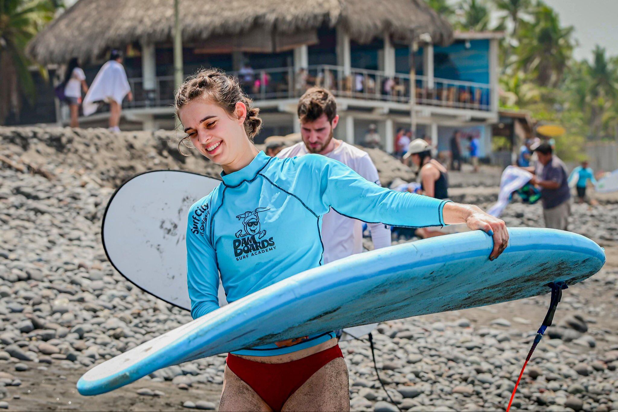 Turista se prepara para ingresar al mar luego de una clase de surf en la playa El Tunco. (Cortesía: Secretaría de Prensa)