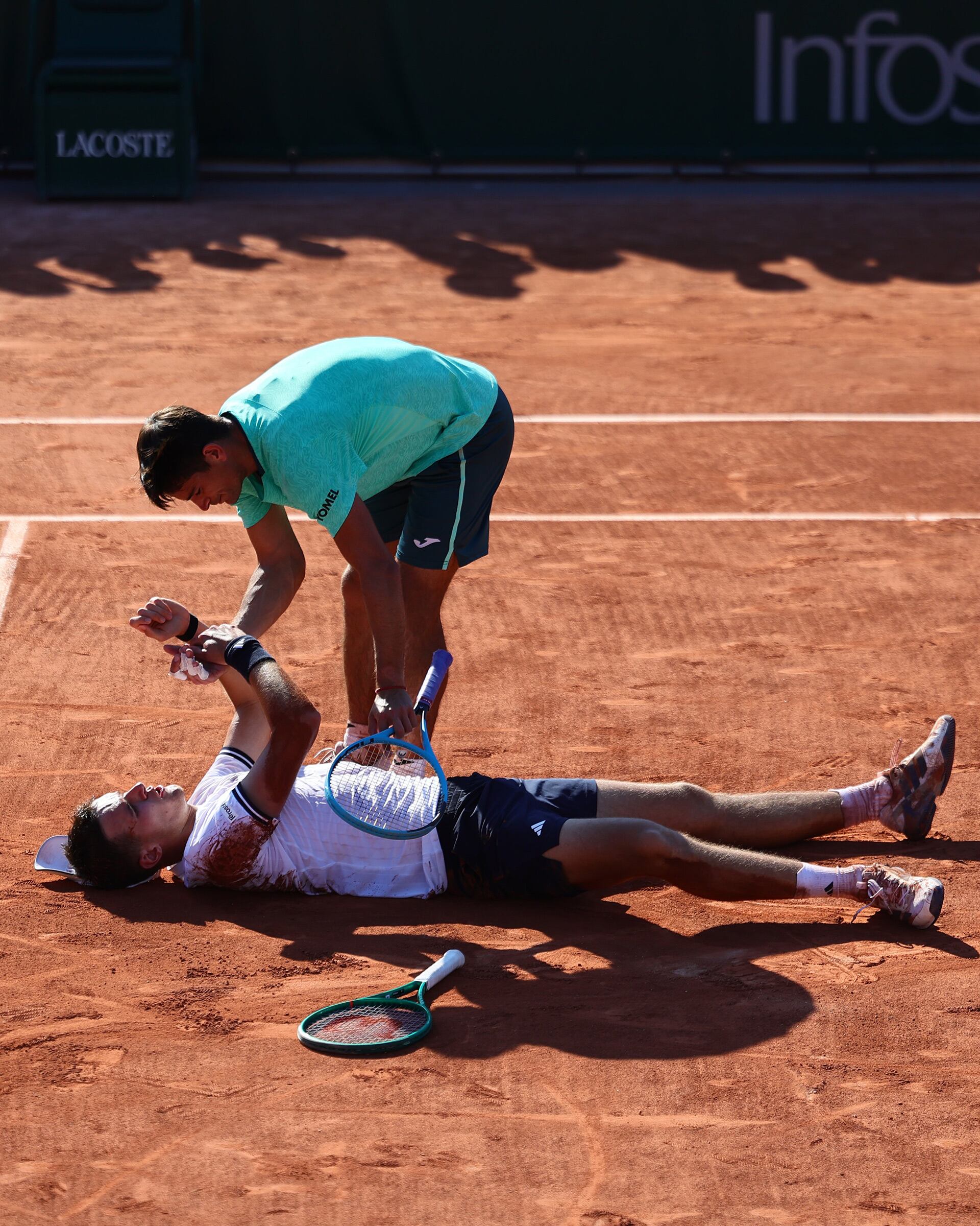 El tenista argentino Mariano Navone se acerca a Jakub Mensik en la cancha de tierra batida de Roland Garros tras su partido, mostrando un gran gesto de deportividad. (Foto: @rolandgarros)