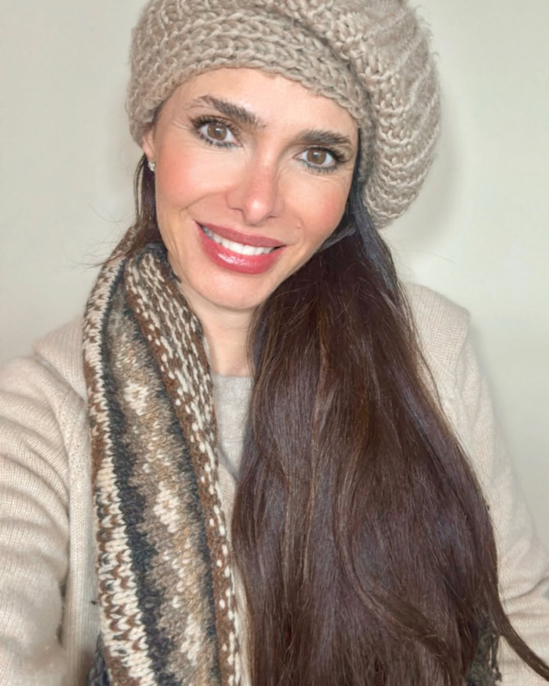 Rossana Almeyda, reconocida por su vínculo con Marcelo Tinelli, sonriente luciendo un gorro y bufanda de lana en tonos neutros