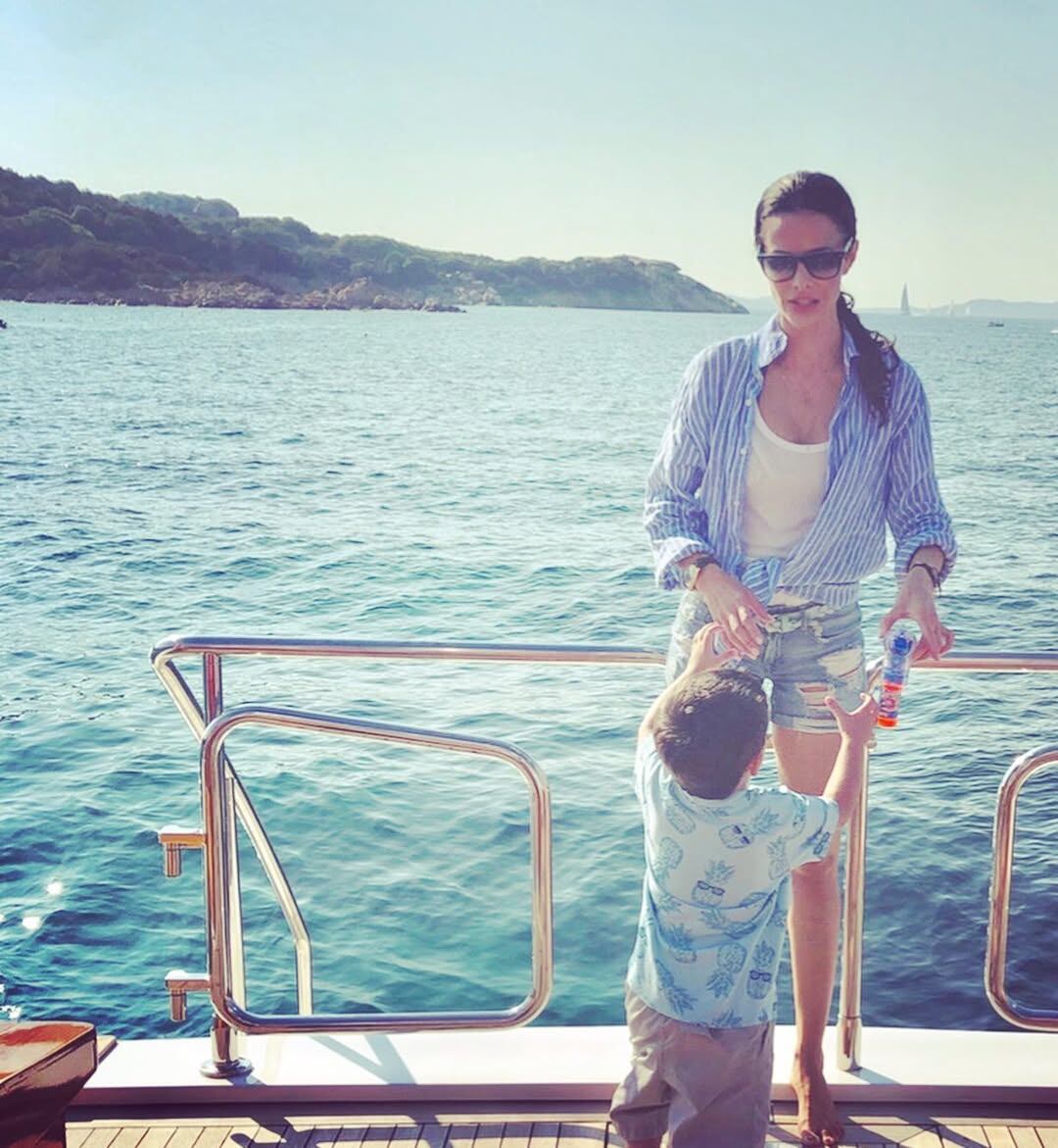 Almeyda y su hijo disfrutan de un momento de alegría y relax en la cubierta de un barco, mientras navegan por aguas tranquilas de Italia 