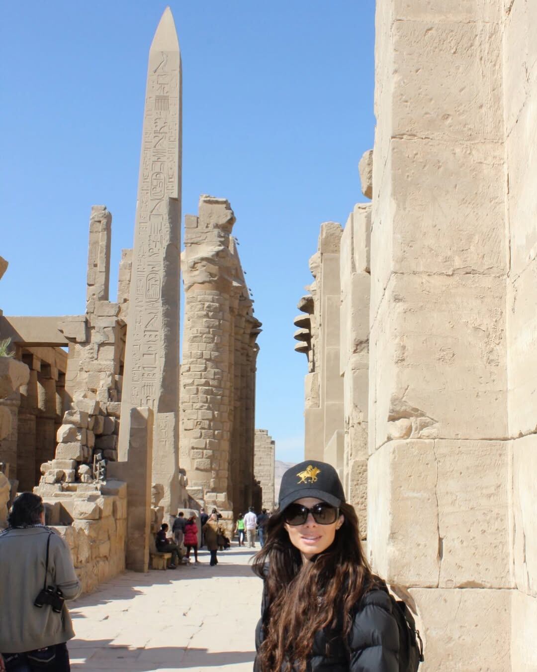 La exmodelo posa con una sonrisa frente a un imponente obelisco y ruinas antiguas de Luxor, Egipto