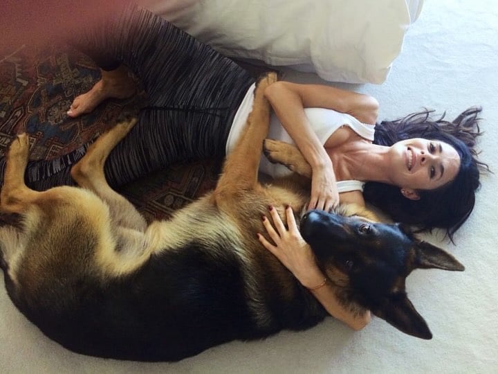  Almeyda disfruta de un íntimo y afectuoso momento junto a su perro, acostada en el suelo con una sonrisa