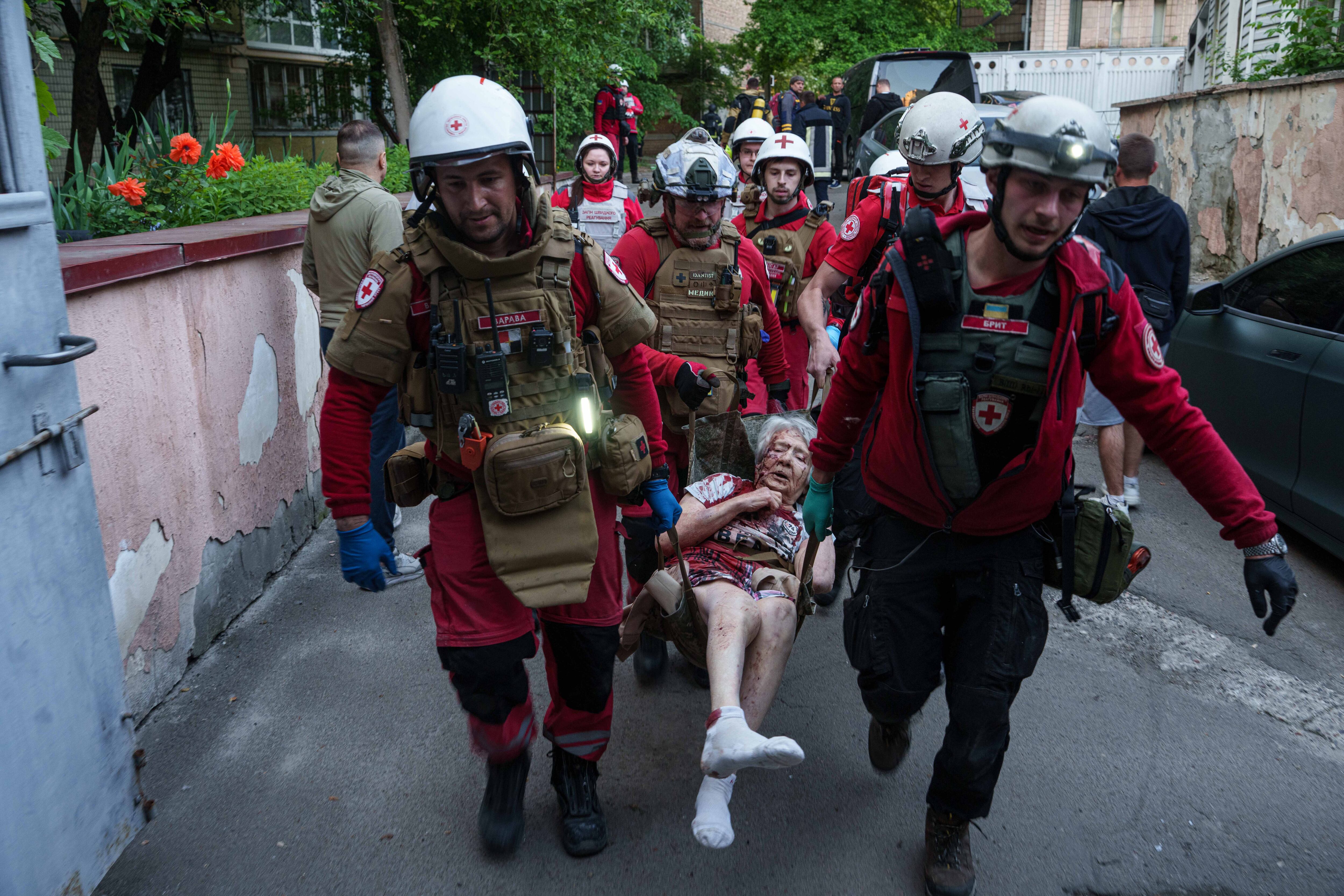 Una residente es trasladada en camilla por voluntarios de la Cruz Roja tras el ataque ruso del domingo sobre un barrio residencial de Kiev, donde el bombardeo dañó edificios en todos los distritos de la capital. (AP Photo/Evgeniy Maloletka)