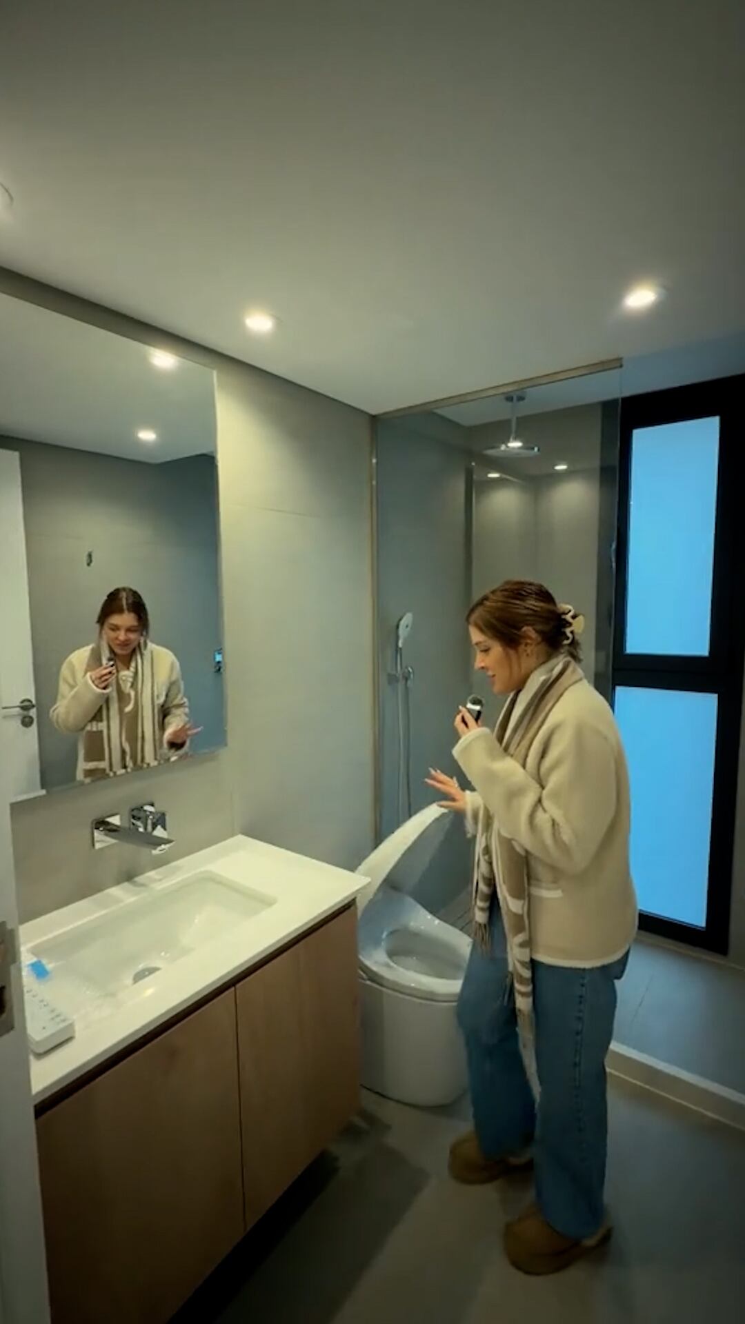 El baño principal sorprende por el inodoro inteligente y detalles modernos como mamparas de vidrio, espejos retroiluminados e iluminación cálida