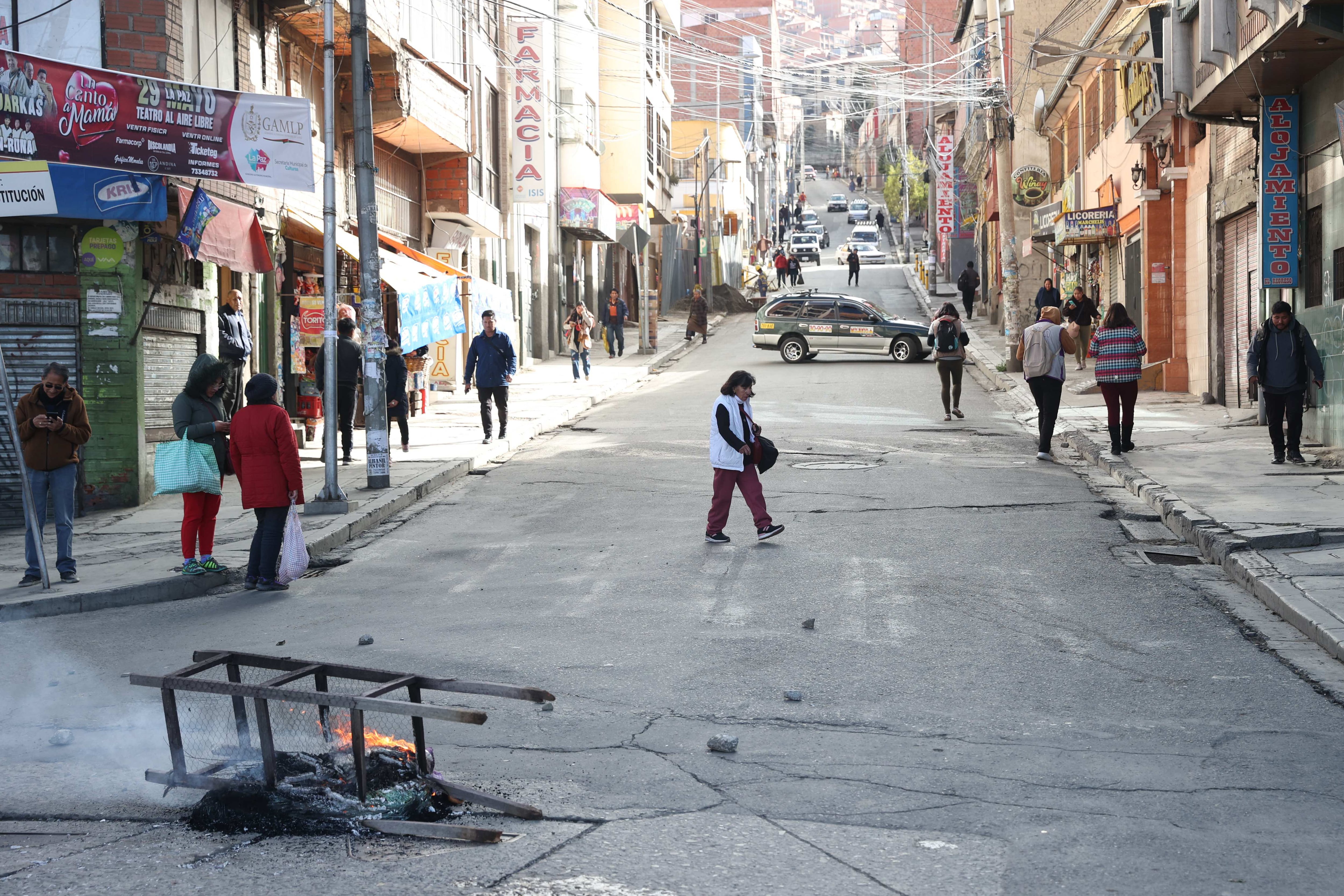Personas caminan por una vía cerrada durante una jornada de bloqueos por parte de transportistas en La Paz (EFE/Luis Gandarillas)